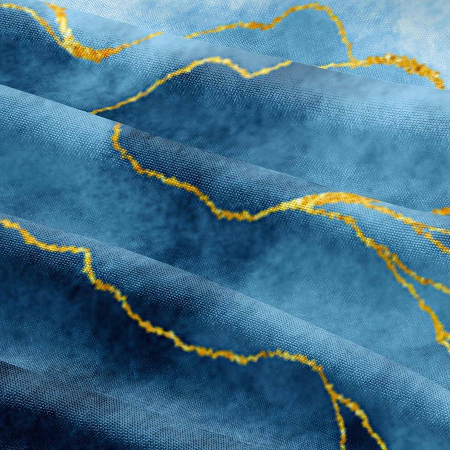 Nahaufnahme von blauem Stoff mit gelben Nahtlinien, die ein strukturiertes, welliges Textilmuster zeigen.