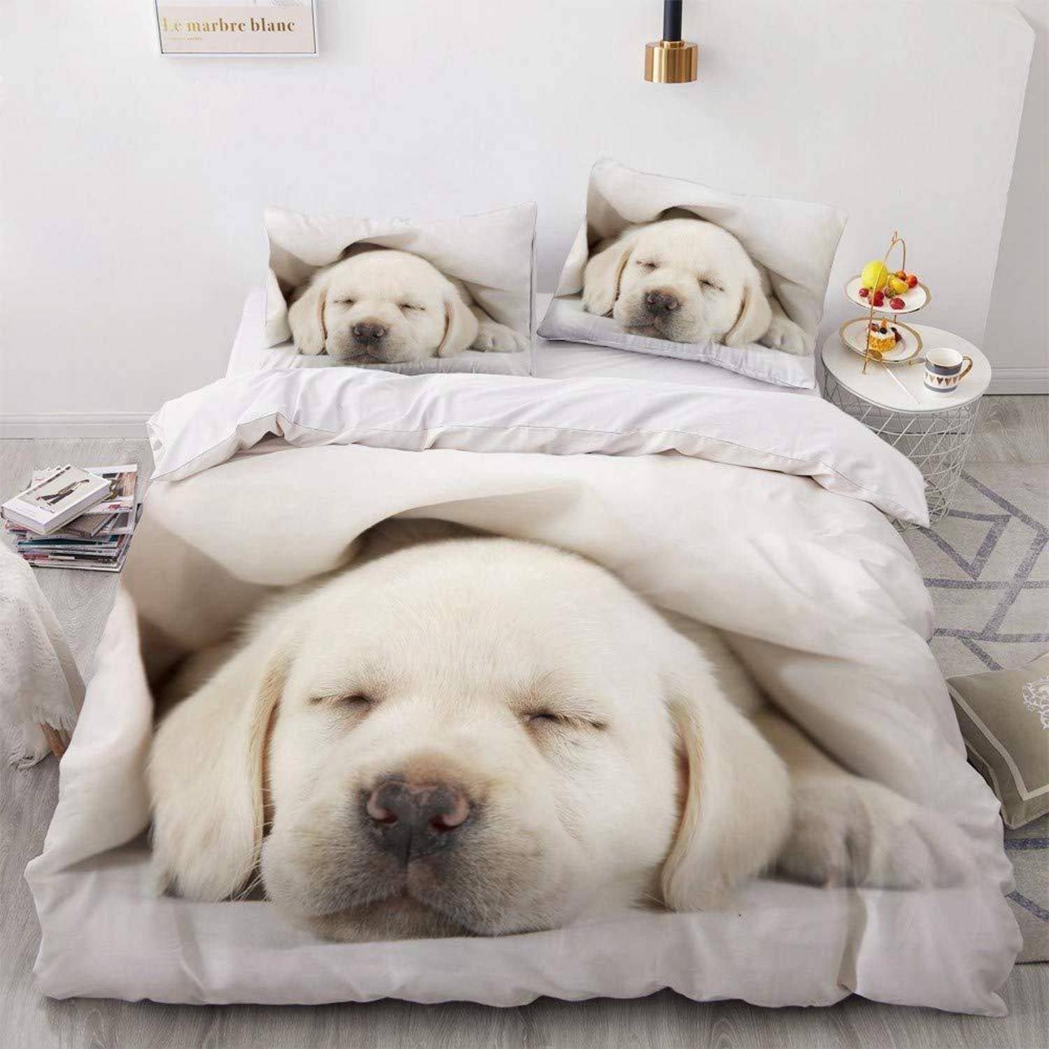 Ein Bettwäscheset mit aufgedruckten schlafenden Labrador-Retriever-Gesichtern, das die Illusion eines hundeförmigen Bettes in einem hellen Schlafzimmer erzeugt.