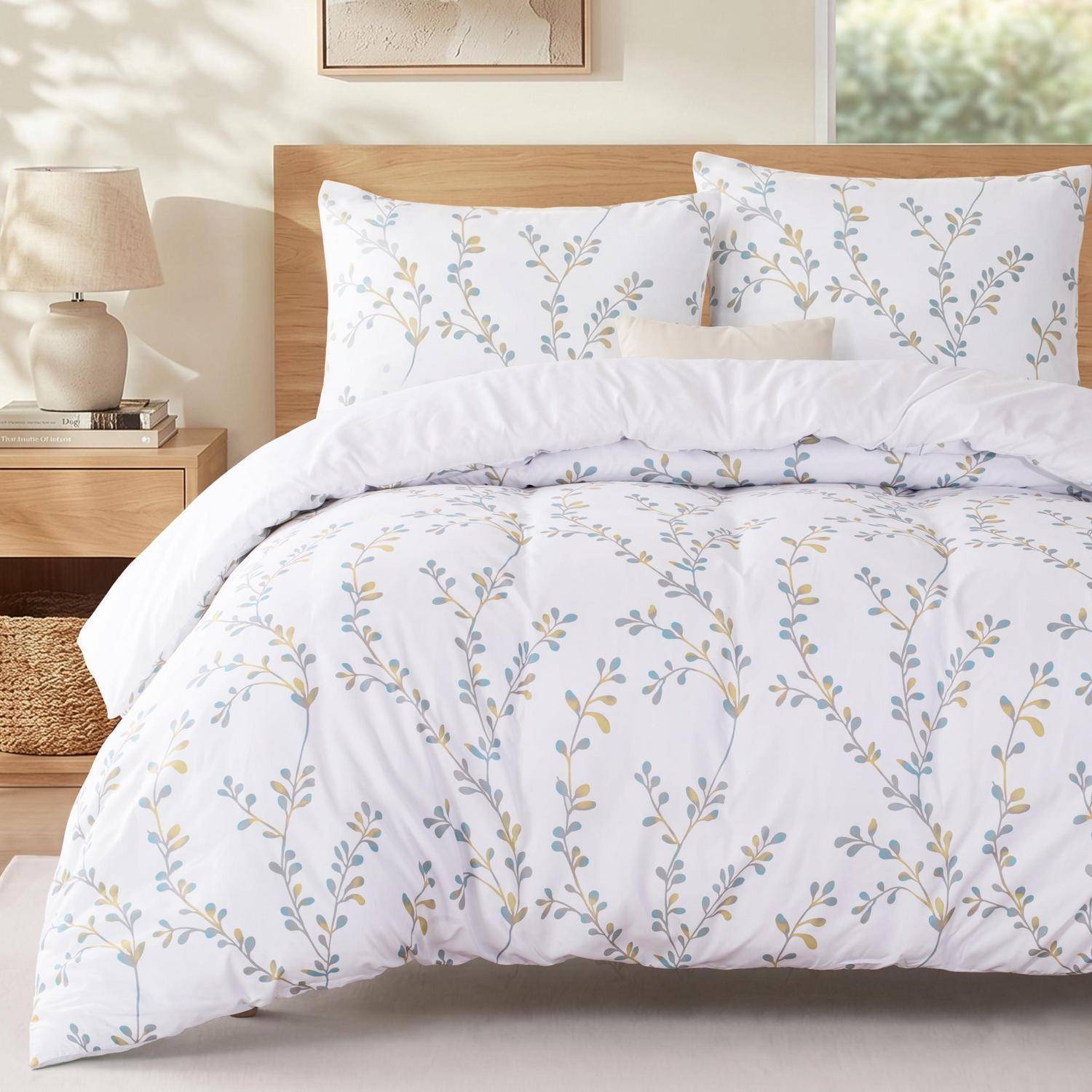 Ein ordentlich gemachtes Bett mit weiß gemusterter Blumenbettdecke vor einem hellholzfarbenen Kopfteil in einer ruhigen Schlafzimmerumgebung.