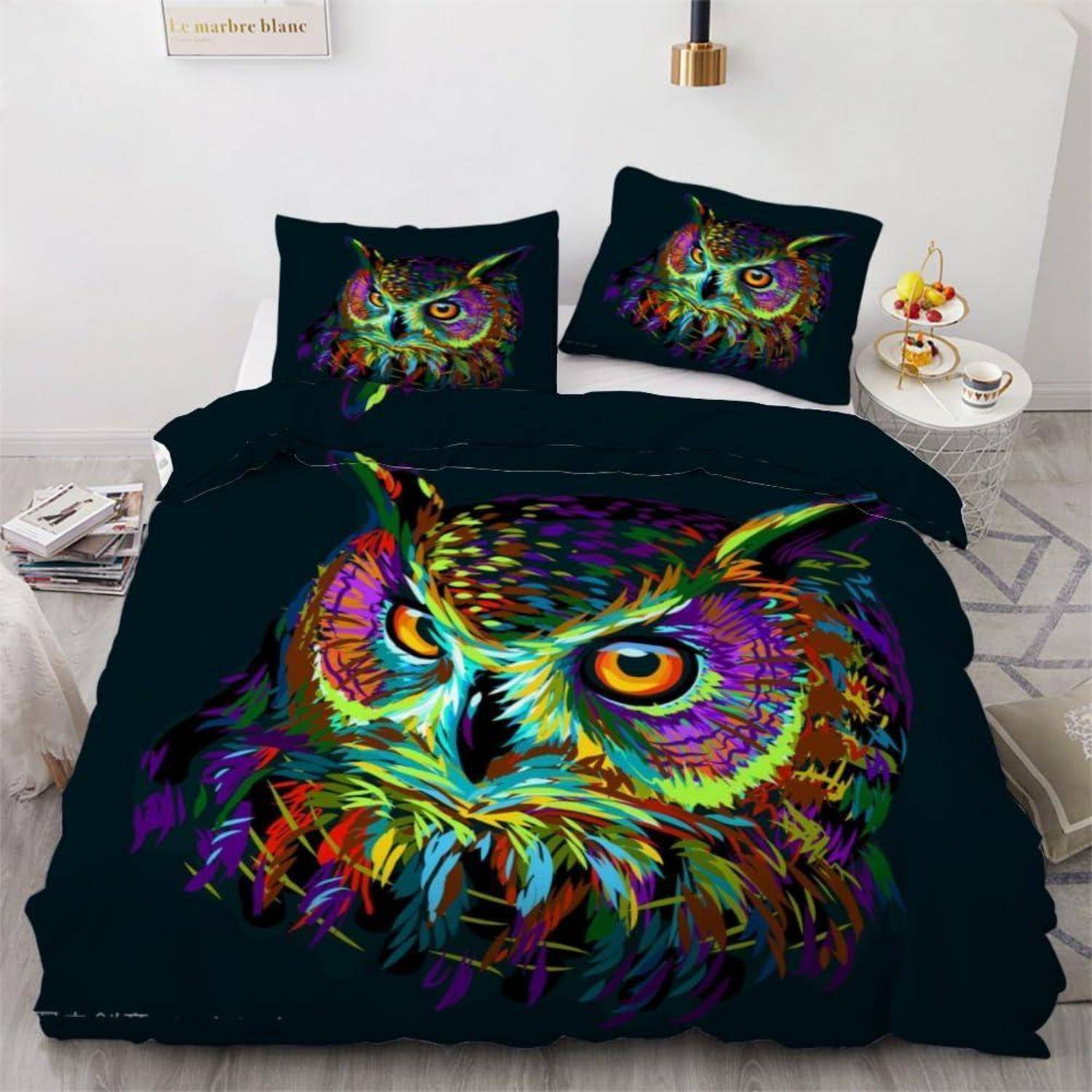 Bett mit dunklem Bettwäscheset, das ein lebendiges mehrfarbiges Eulenmotiv auf der Bettdecke und den Kissen zeigt.