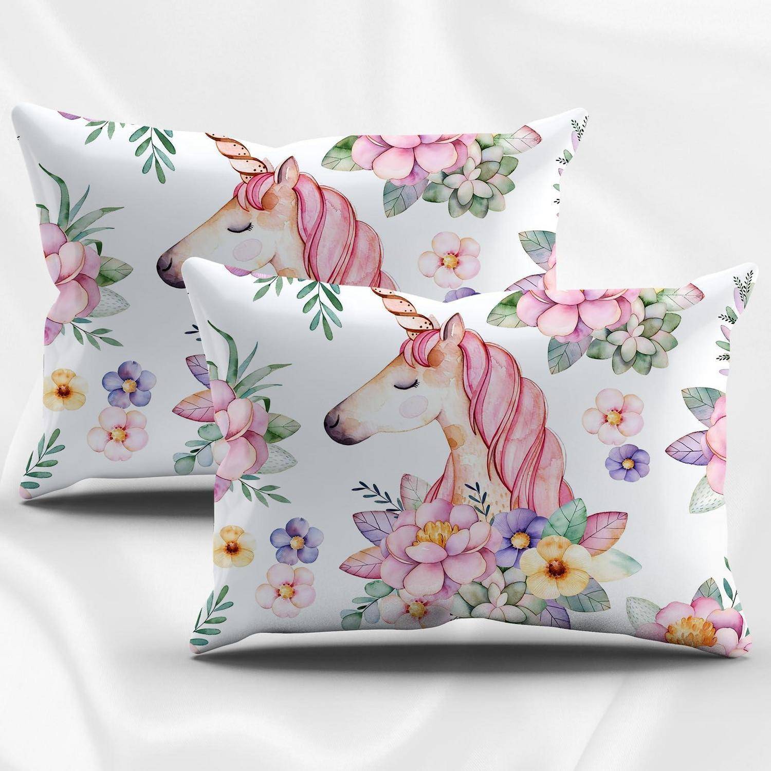 Zwei dekorative Kissen mit Aquarell-Einhorn- und Blumenmotiv auf weißem Hintergrund.