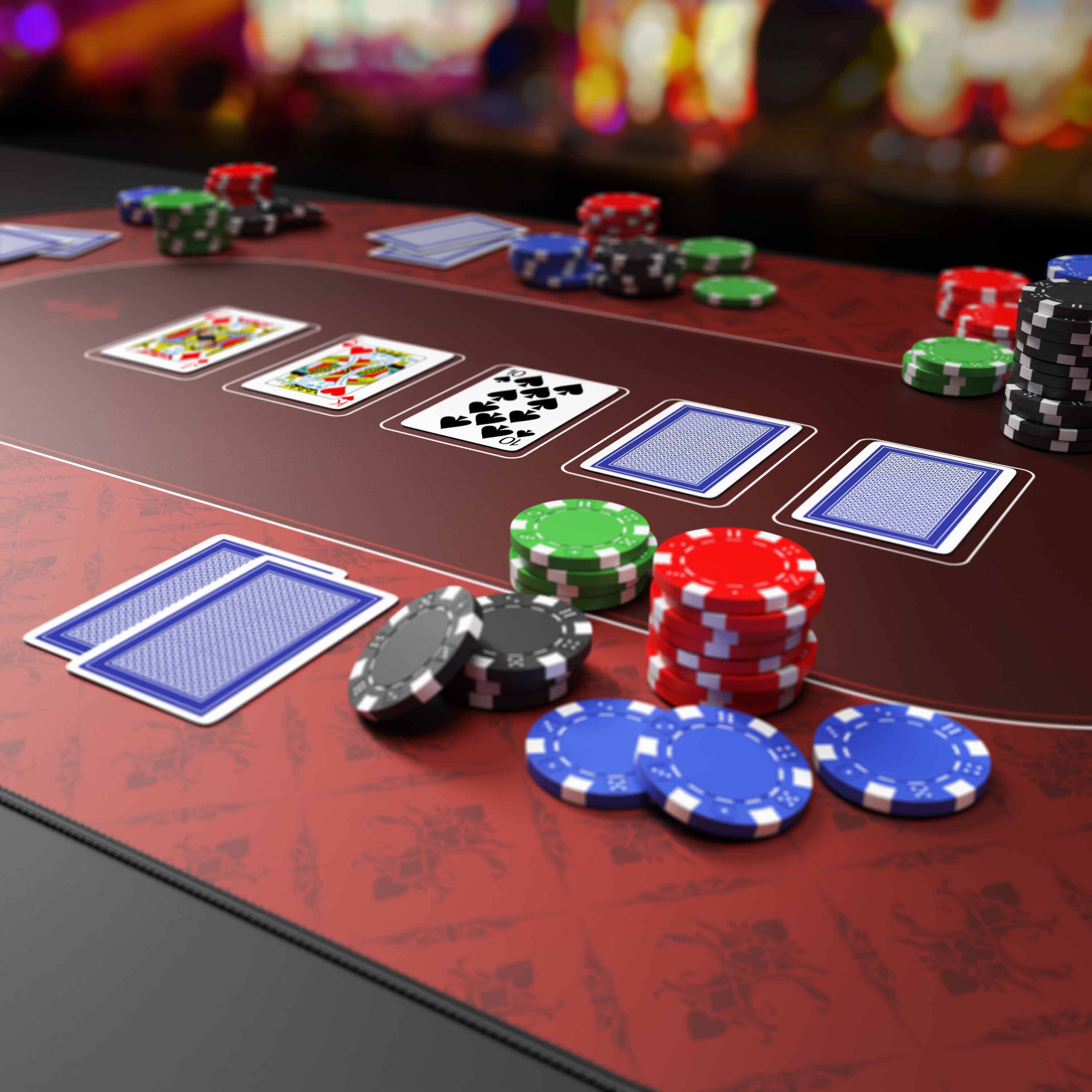 Pokertisch mit aufgedeckten Karten und Stapeln von Casino-Chips, die ein aktives Kartenspiel in Aktion zeigen.