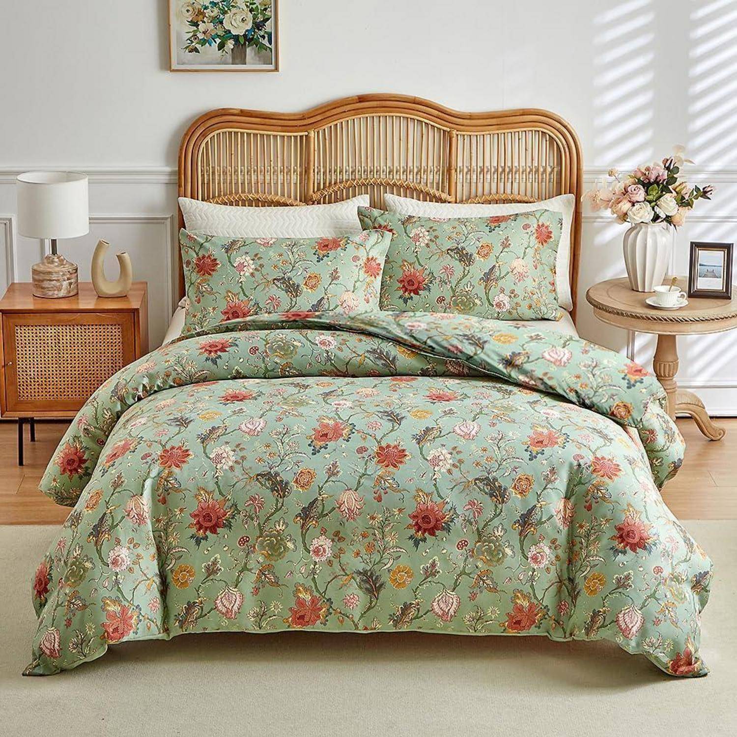 Ein ordentlich gemachtes Bett mit einer floralen mintgrünen Bettdecke und passenden Kissen, eingerahmt von einem geflochtenen Rattan-Kopfteil und Nachttischen in einem hellen Schlafzimmer.