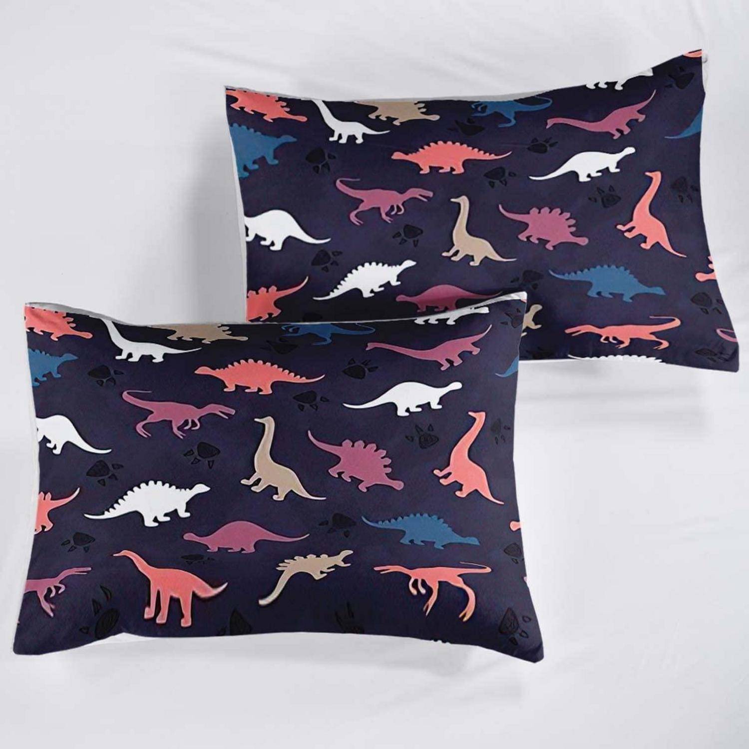Zwei Kissenbezüge mit Dinosaurier-Muster in Dunkelblau mit farbigen Dinosaurier-Silhouetten, übereinander gestapelt auf weißem Hintergrund gezeigt.