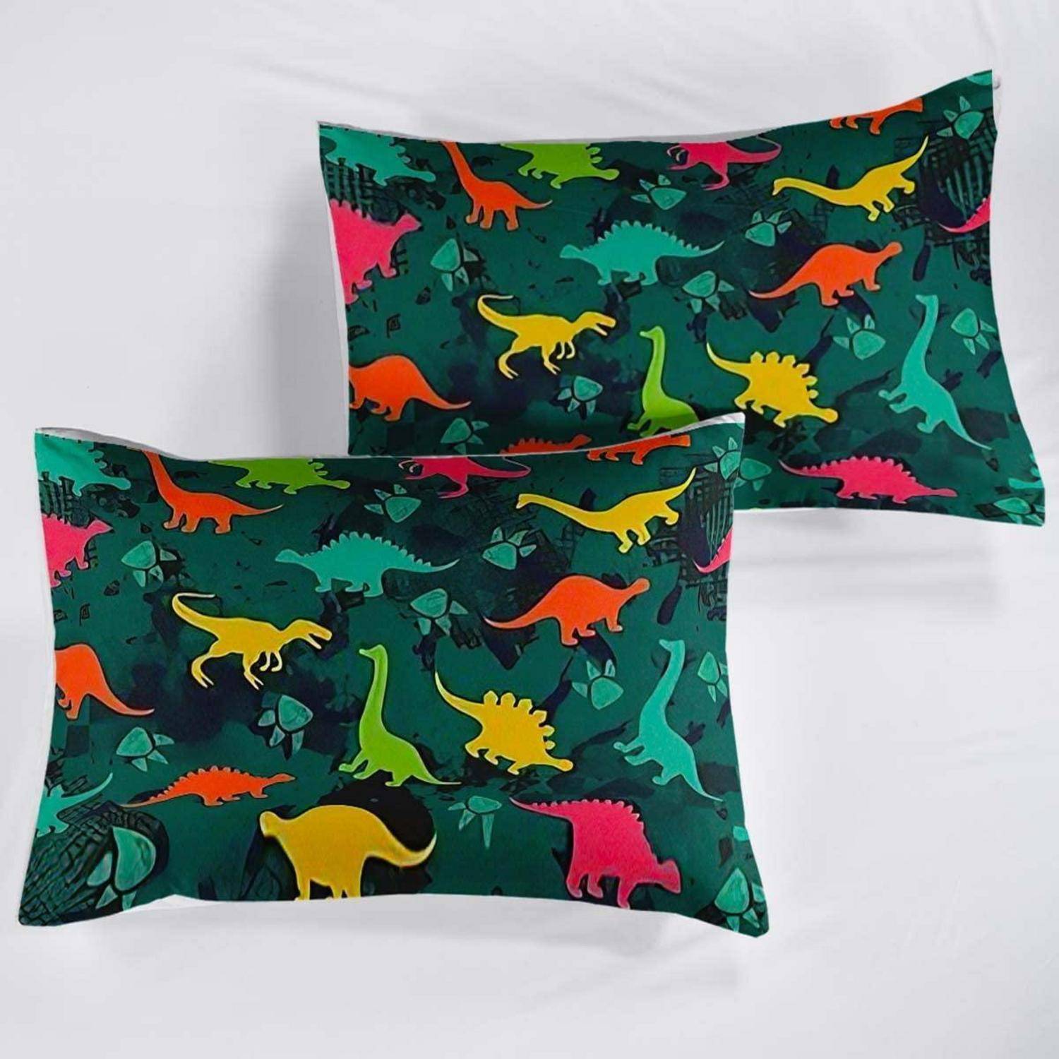 Zwei Kissenbezüge mit Dinosaurier-Muster auf weißem Hintergrund, einer vor dem anderen, mit bunten grünen, gelben, orange- und rosafarbenen Dinosauriern.