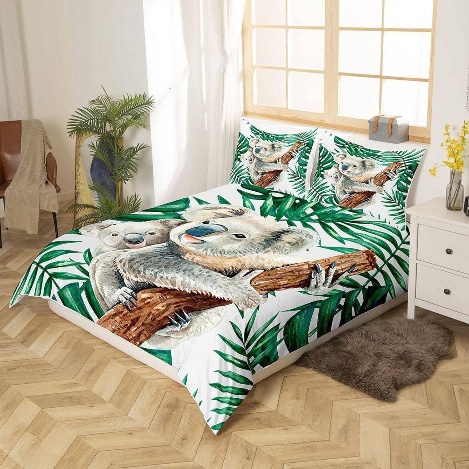 Bett mit koala-themenbettwäsche mit großem Koaladruck und grünen Palmblättern in einem hellen Schlafzimmer.