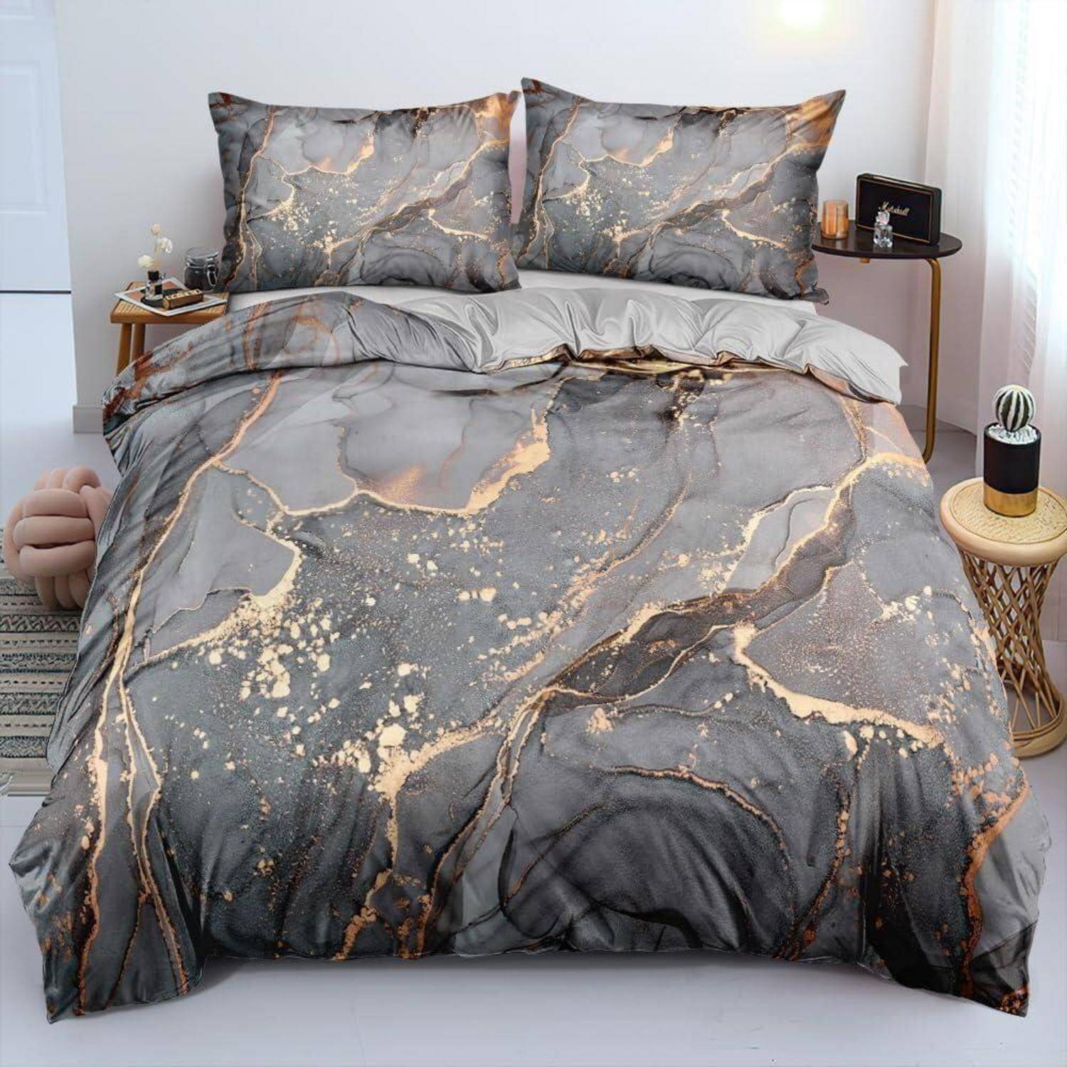Ein grau marmoriertes Bettwäsche-Set mit goldenen Adern, bestehend aus einem Bettdeckenbezug und zwei Kissenbezügen auf einem ordentlich gemachten Bett.