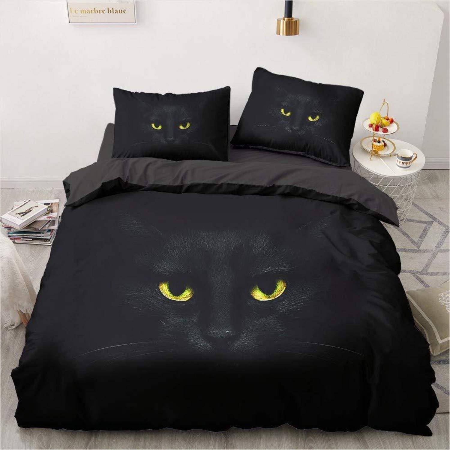 Schwarzes Bettwäscheset mit leuchtenden gelben Katzenaugen, die auf der Bettdecke und den Kissenbezügen bedruckt sind, gezeigt auf einem ordentlich gemachten Bett in einem Schlafzimmer.
