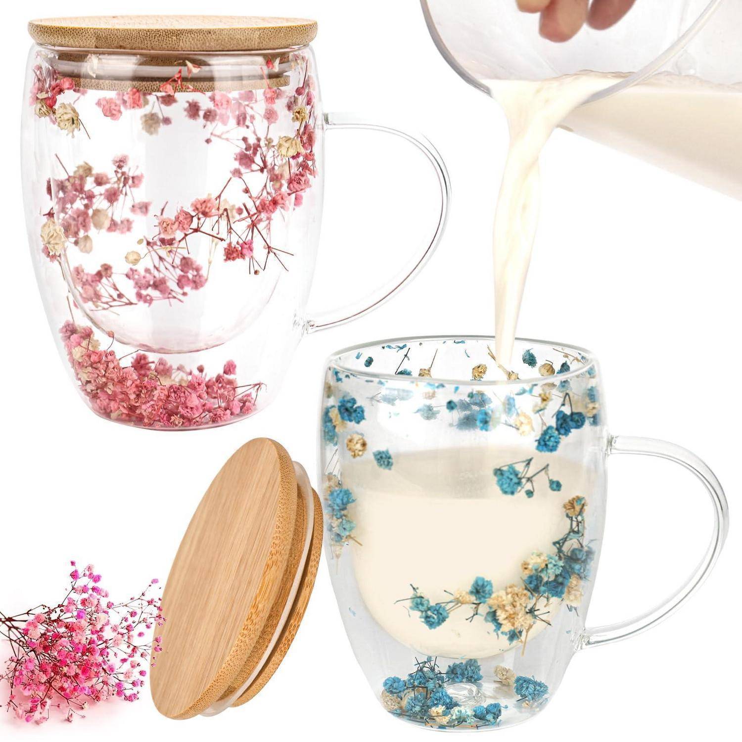 Zwei florale Glastassen mit Bambusdeckeln; eine ist mit Milch gefüllt, während eine Hand Milch in die andere gießt.