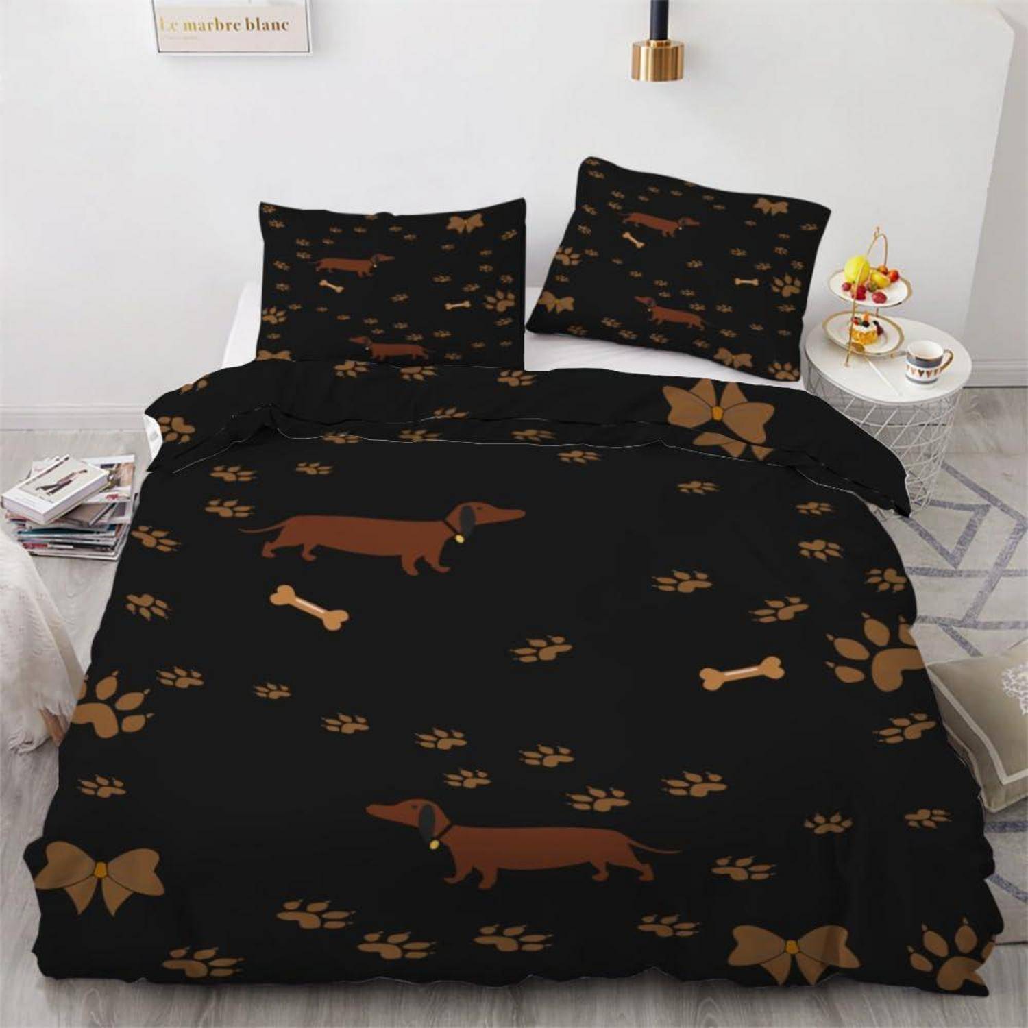 Bett mit schwarzem Dackel und Pfotendruck-Bettwäsche, zwei passende Kissen, in einem hellen Schlafzimmer.