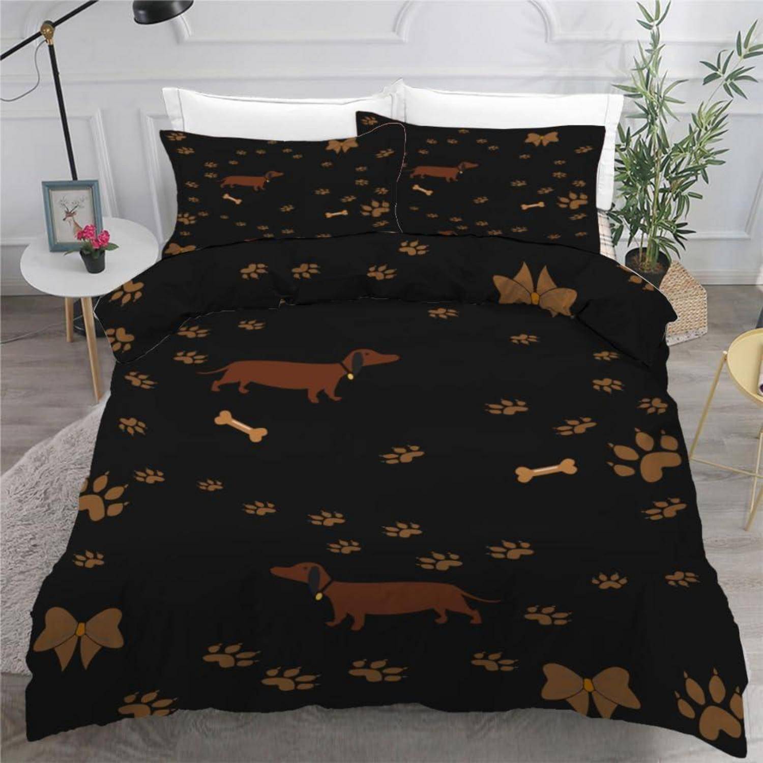 Schwarzes Bettwäsche-Set mit Dackel-, Pfotendruck-, Knochen- und Schleifen-Muster in einem Schlafzimmer.
