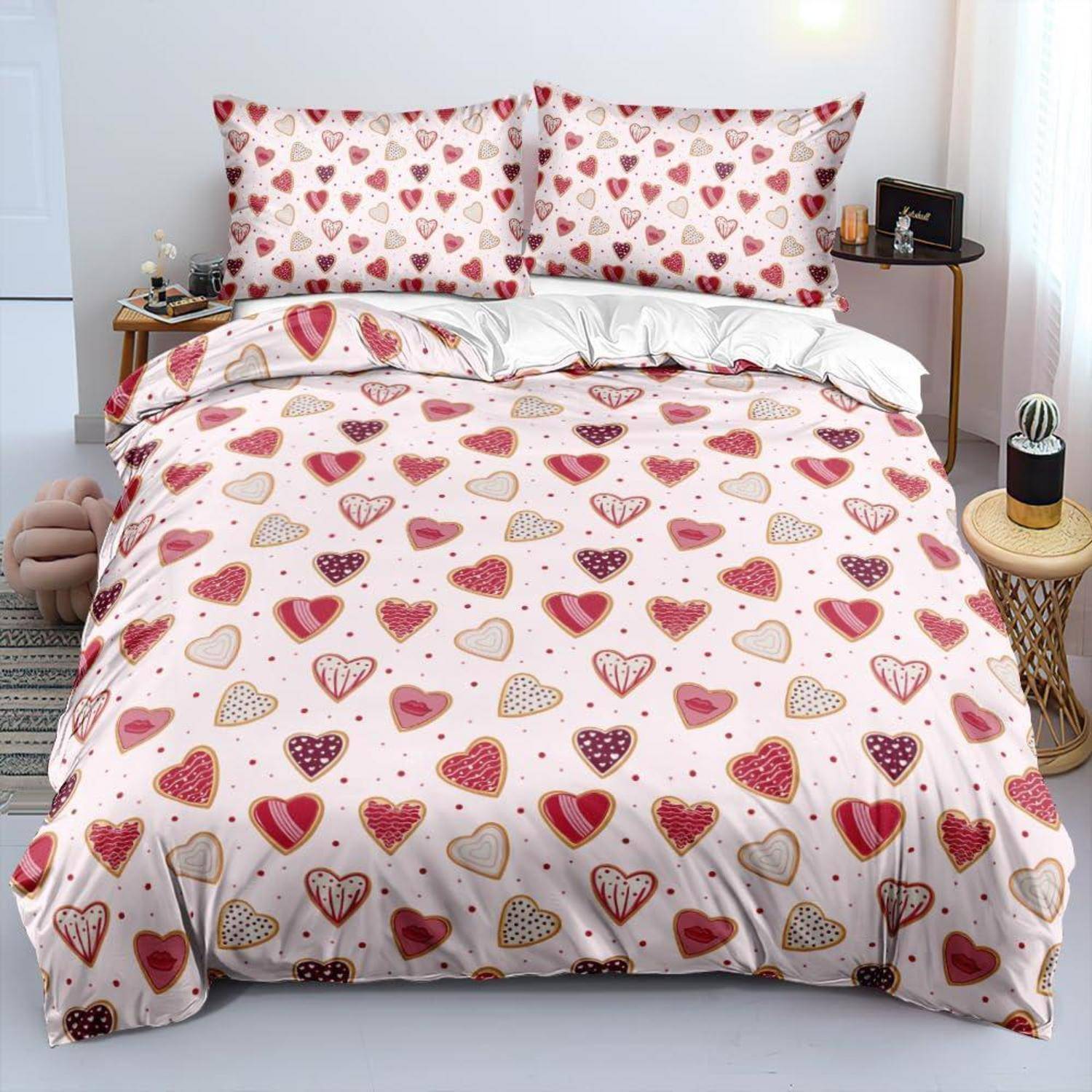 Bett mit herzgemusterter Bettwäsche und passenden Kissen in einem hellen Schlafzimmer.