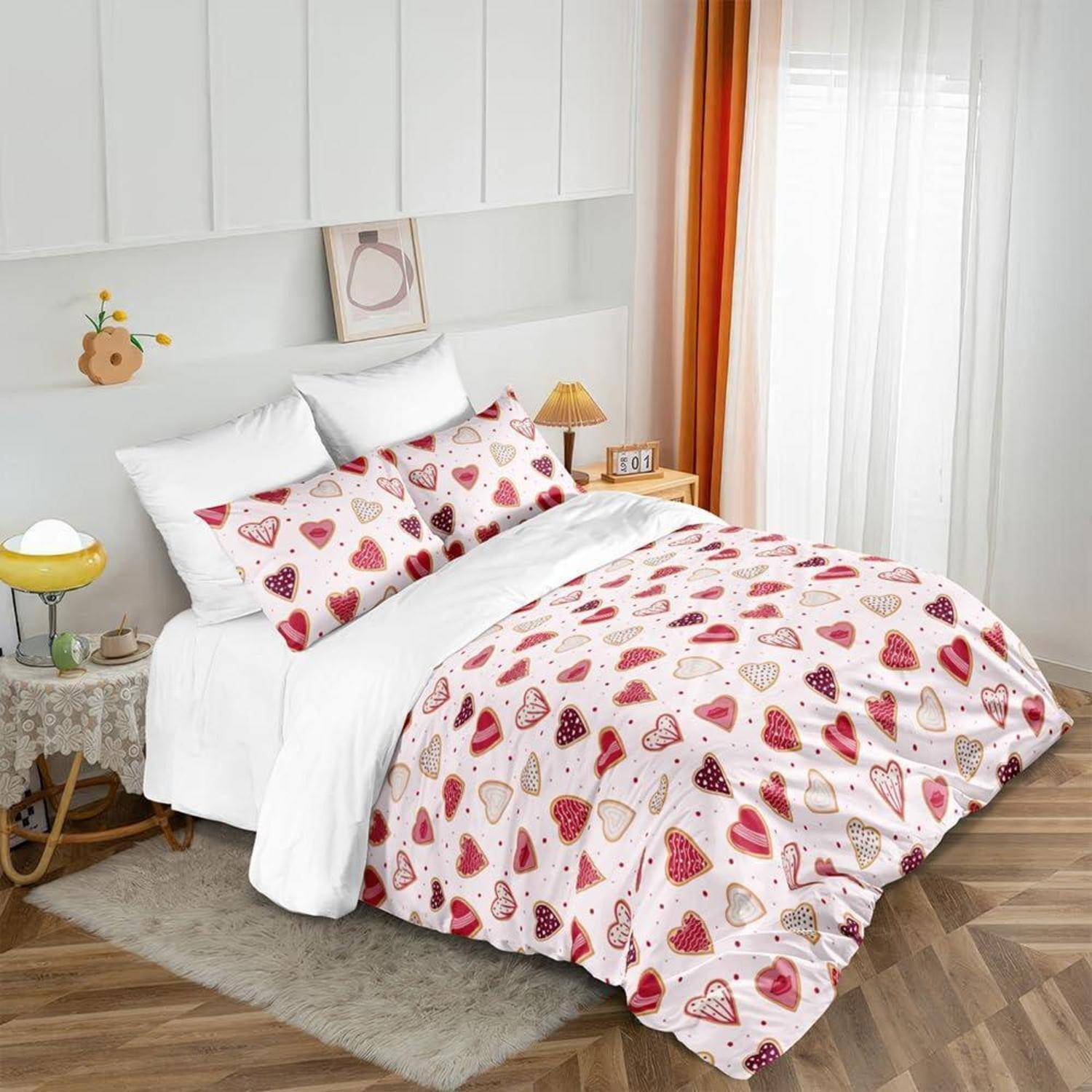 Helles Schlafzimmer mit einem weißen Bett, das in herzgemusterter rosa und roter Bettwäsche gekleidet ist, gezeigt mit Kissen, Nachttischen und Vorhängen.