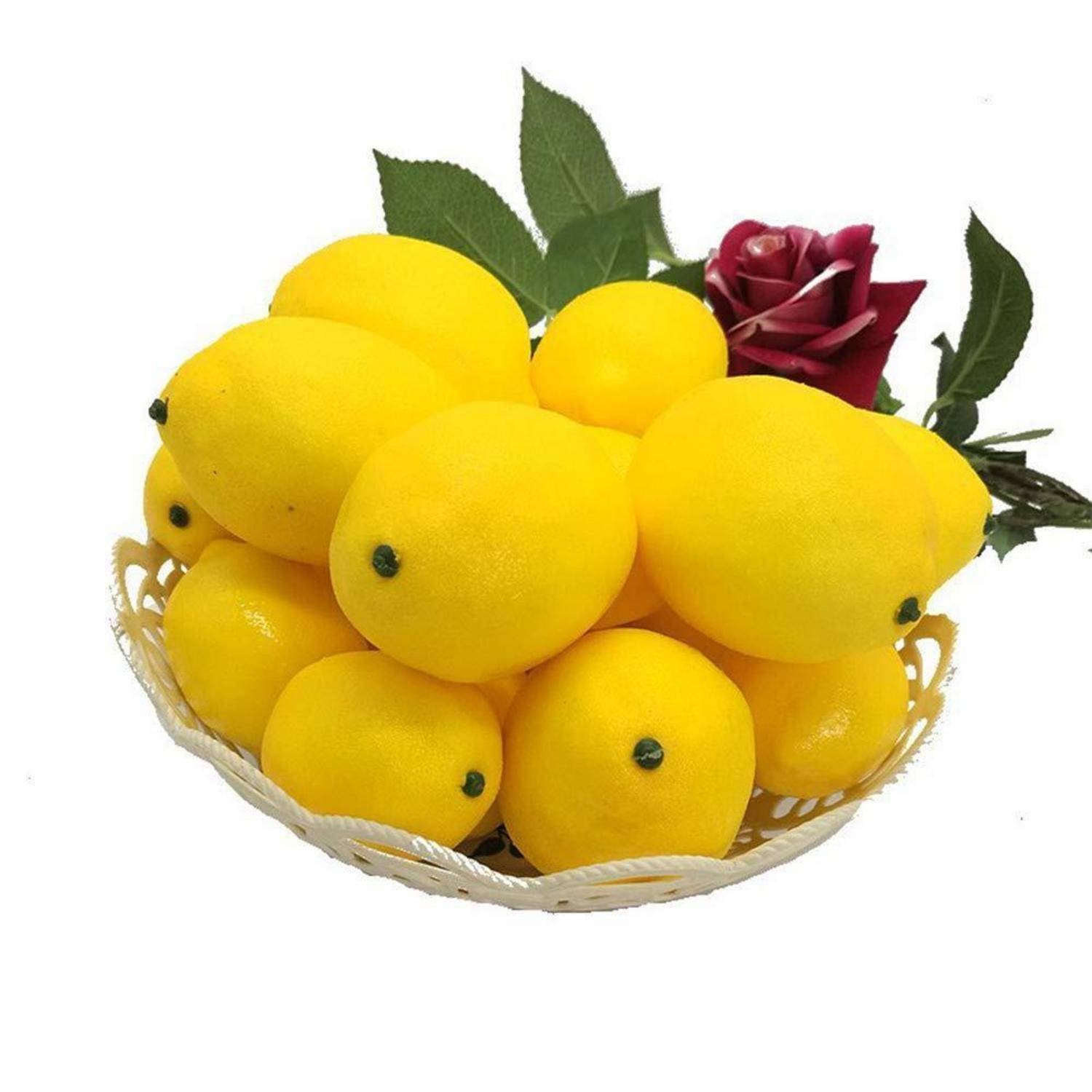 Korb mit leuchtend gelben Zitronen, arrangiert mit grünen Blättern und einer roten Rose auf weißem Hintergrund.