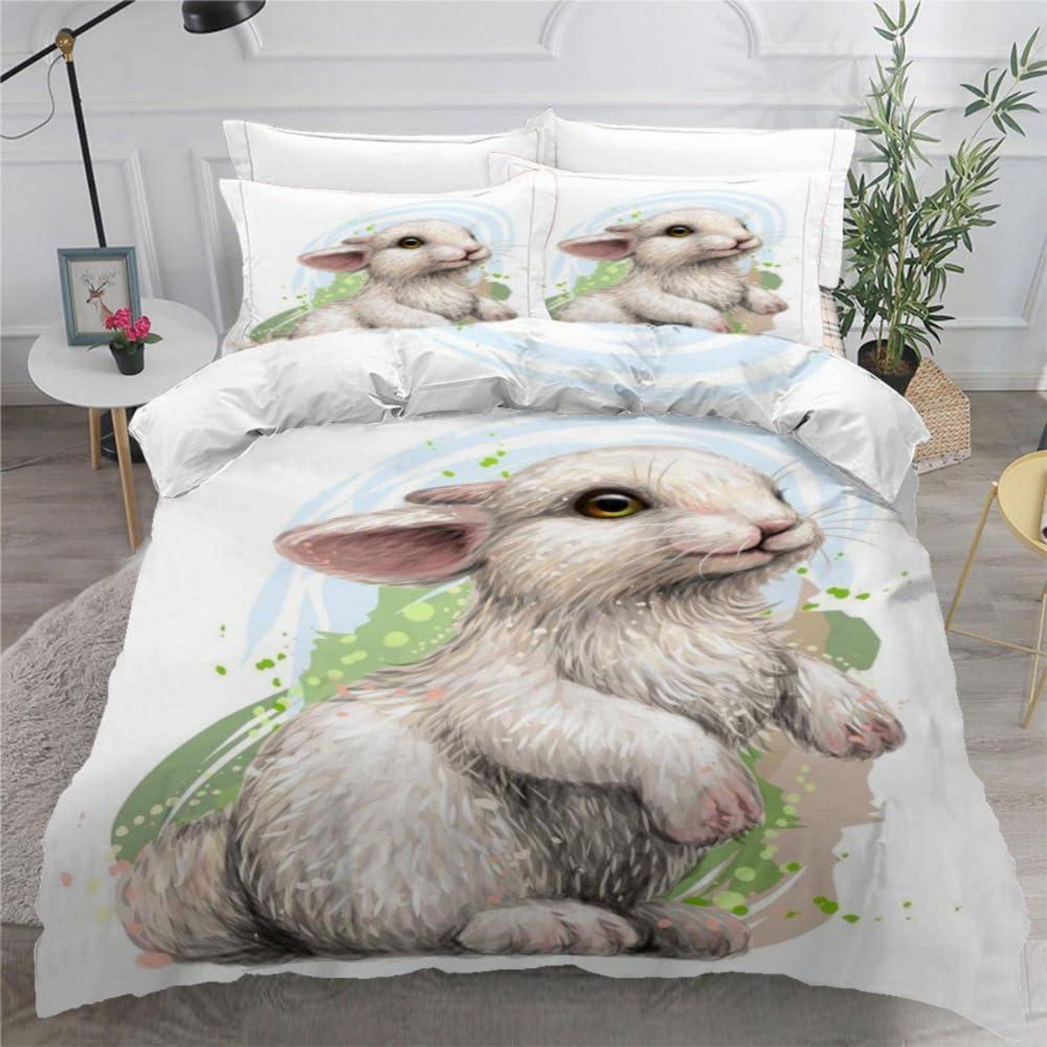 Bett mit weißer Hasenmotiv-Bettwäsche: Bettdecke und Kissen zeigen einen großen illustrierten Baby-Hasen, mit passenden kleineren Hasenbildern auf den Kissen.