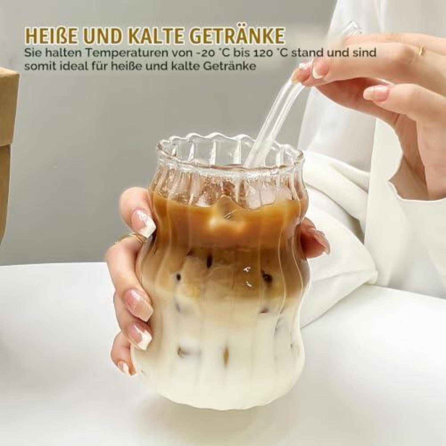 Hand hält einen eiskalt geschichteten Kaffee in einem klaren strukturierten Glas mit einem Strohhalm; deutscher Text besagt, dass er Temperaturen von -20°C bis 120°C für heiße und kalte Getränke beibehält.