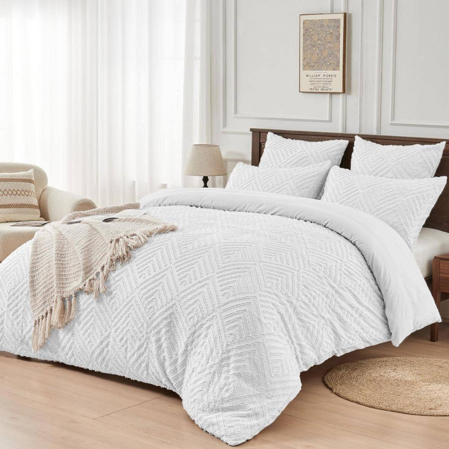 Weißes strukturiertes Bettgesteck und Kissen auf einem gemachten Bett in einem hellen, neutralen Schlafzimmer mit hölzernem Kopfteil, Nachttischlampe und Teppich.