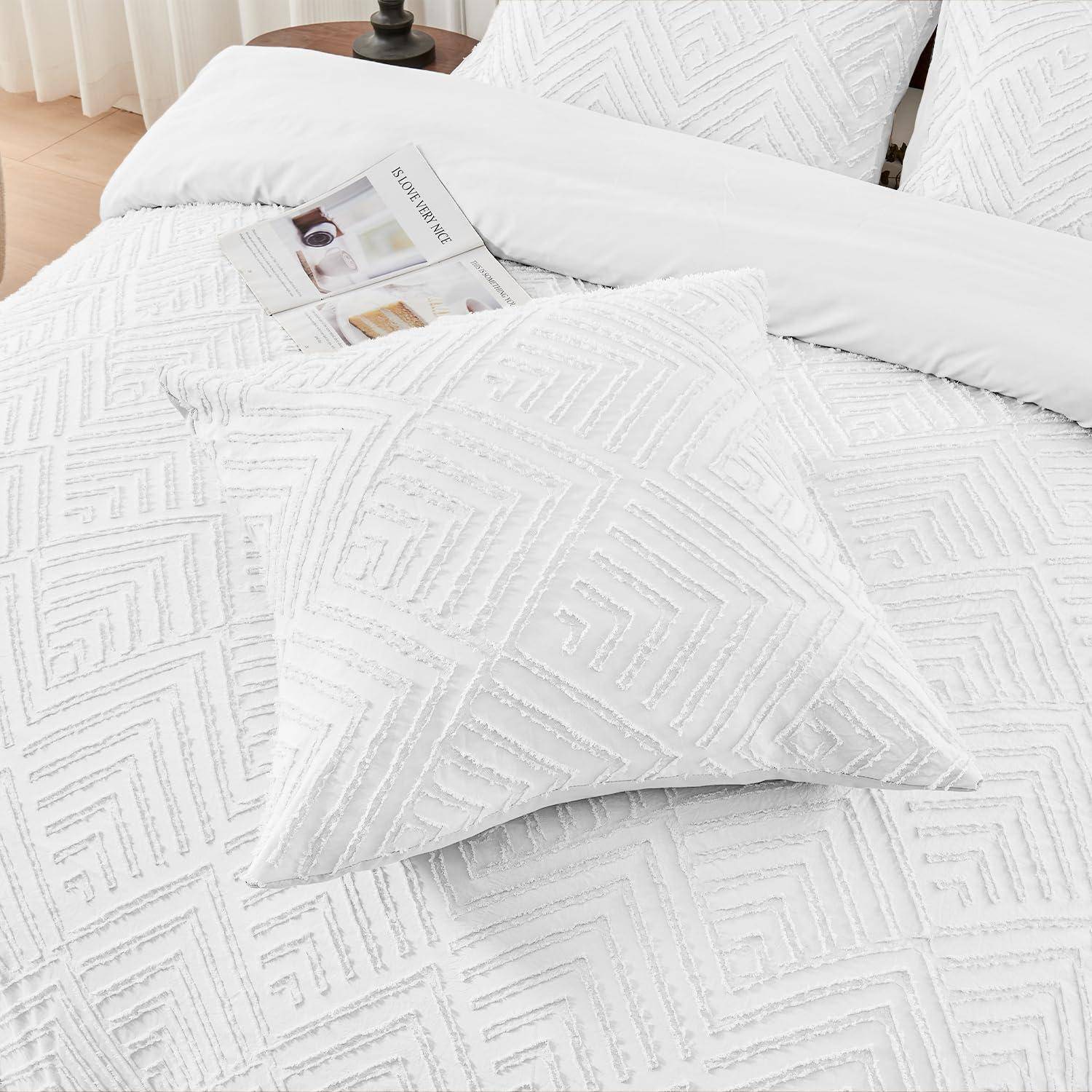 Weißes Bett mit strukturierter geometrischer Bettdecke und Kissen, mit einer Zeitschrift, die in der Nähe des Kopfendes ruht.