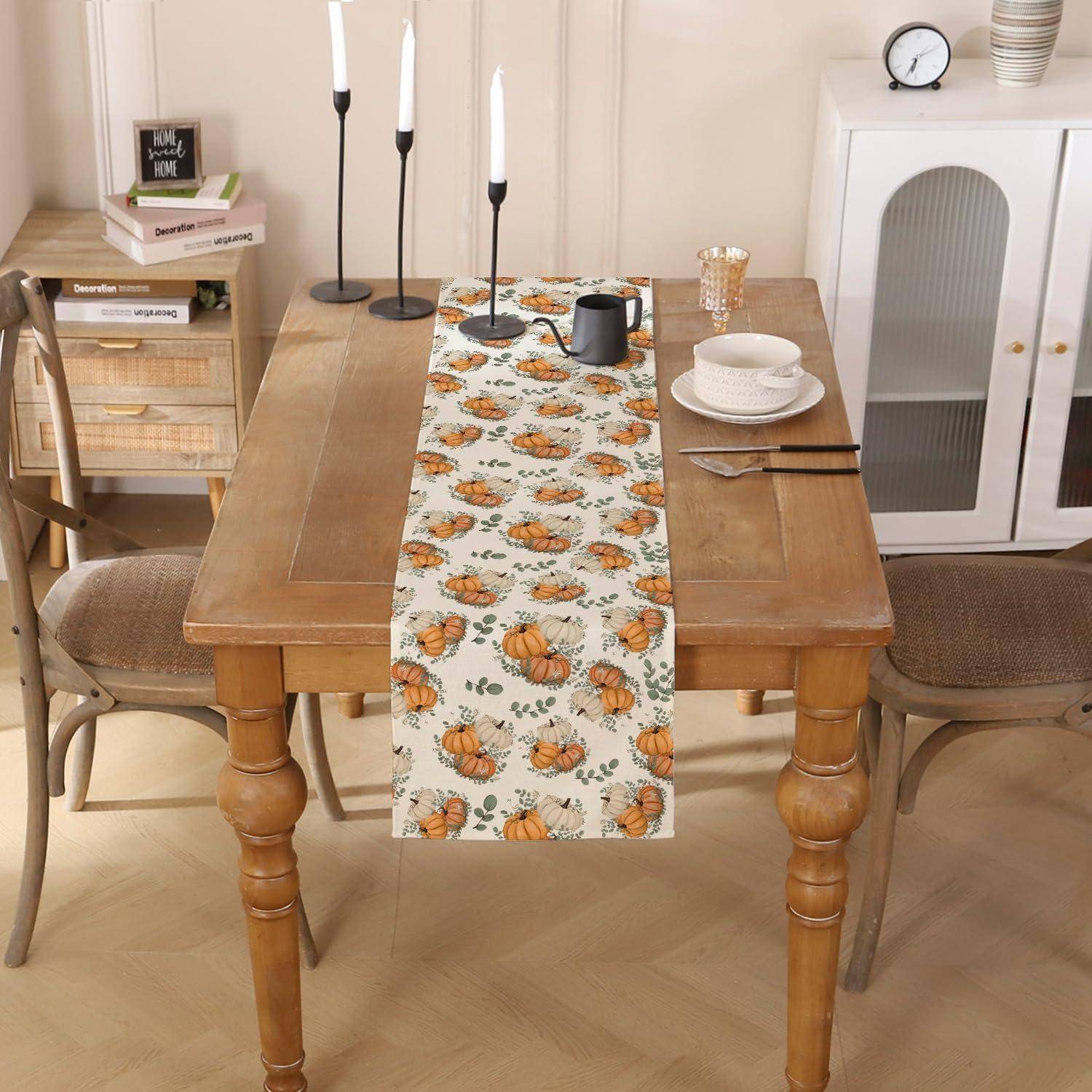Esstisch für den Herbst eingedeckt: Holztisch mit Kürbis-Tischläufer, Kerzen, Geschirr und vier Stühle in einem gemütlichen Raum.