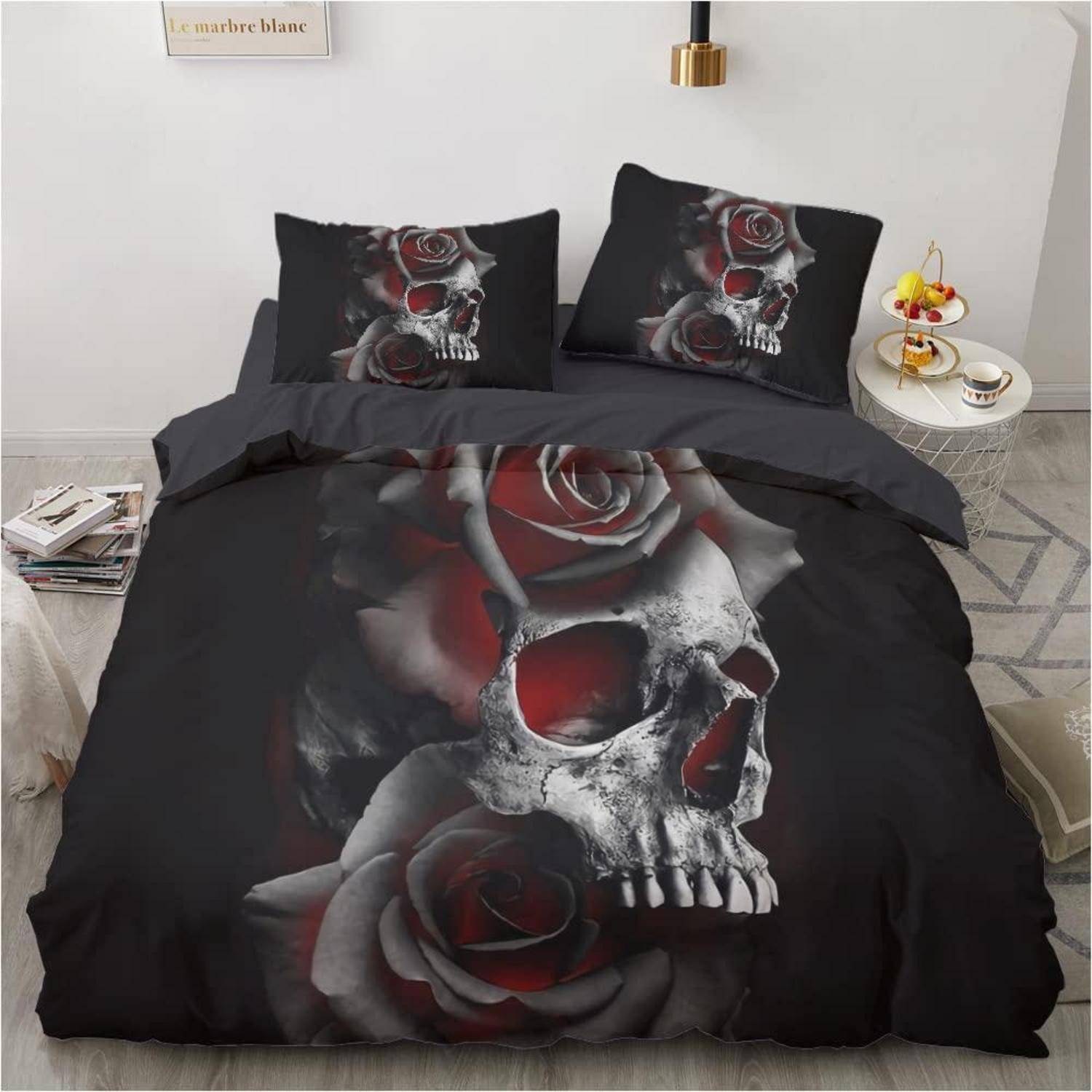 Schwarze Bettwäsche-Set mit großem Totenkopf- und rotem Rosendruck auf Bettdecke und Kissen, dargestellt auf einem ordentlich gemachten Bett in einem minimalistischen Schlafzimmer.