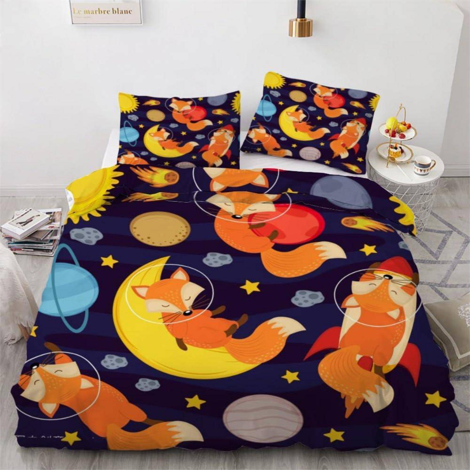 Ein Bett mit Bettwäsche im Fuchs-und-Planeten-Design: dunkelblaue Bettdecke und Kissen mit orangefarbenen Füchsen, Monden, Sternen und Planeten bedruckt.