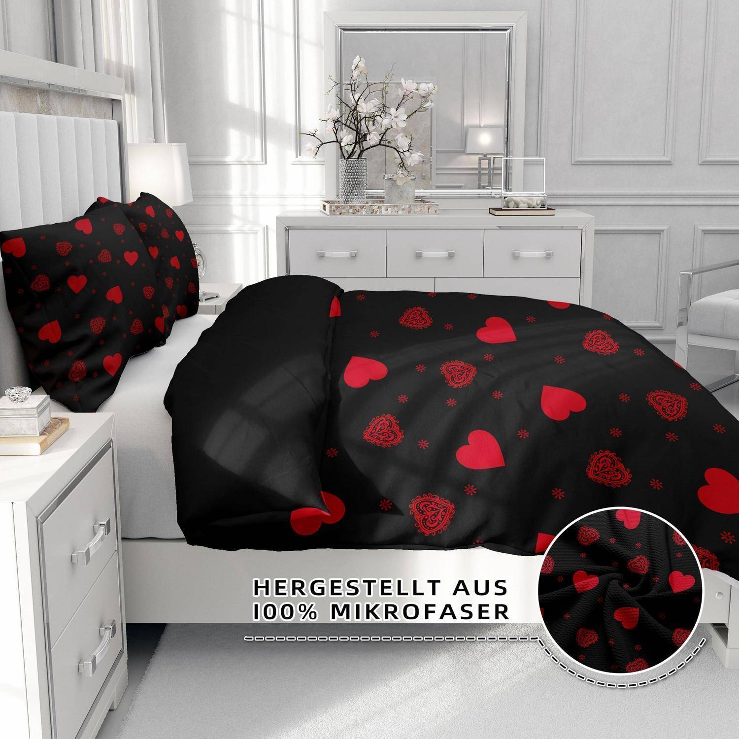 Schwarzes Bettwäscheset mit roten Herzen und Rosen in einem weißen Schlafzimmer, gekennzeichnet mit „HERGESTELLT AUS 100% MIKROFASER" mit einer Nahaufnahme des Stoffeinsatzes.