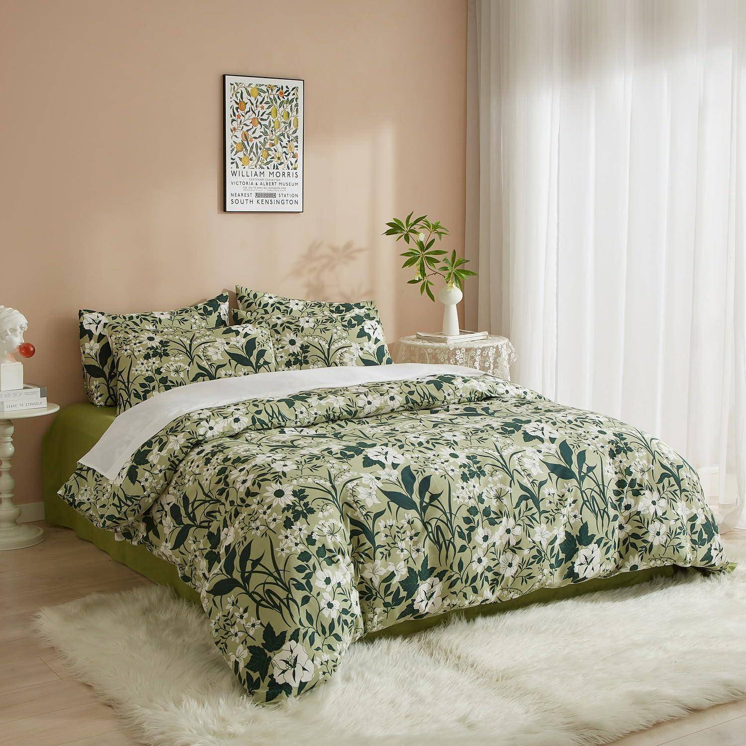 Ein ordentlich gemachtes Bett mit grünem Blumenbettzug in einem hellen Schlafzimmer, neben durchsichtigen Vorhängen, einem kleinen Nachttisch und Wandkunst.