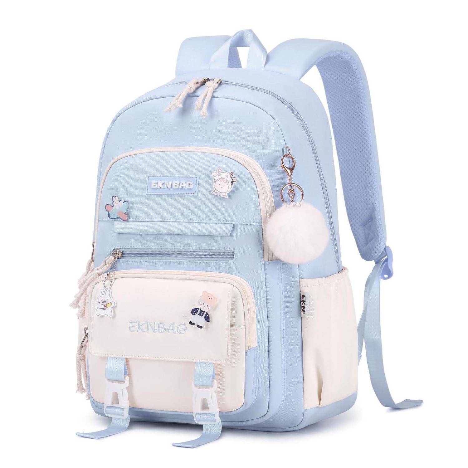 Hellblauer und cremefarbener Rucksack mit vorderen Taschen, Cartoon-Patches und einem flauschigen Pompom-Anhänger auf weißem Hintergrund.