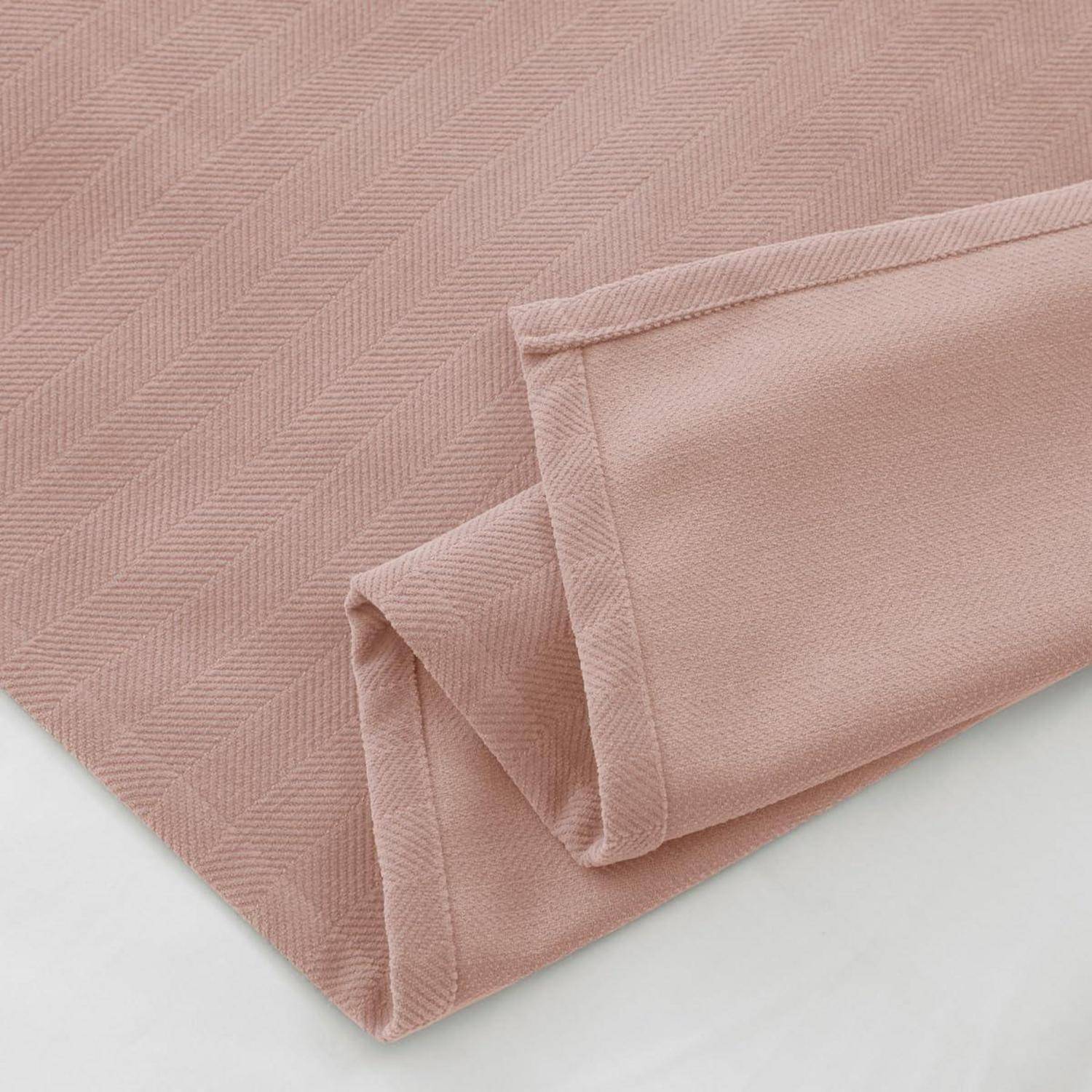 Nahaufnahme von gefälteltem zartem rosa strukturiertem Stoff mit genähten Kanten auf weißem Hintergrund.