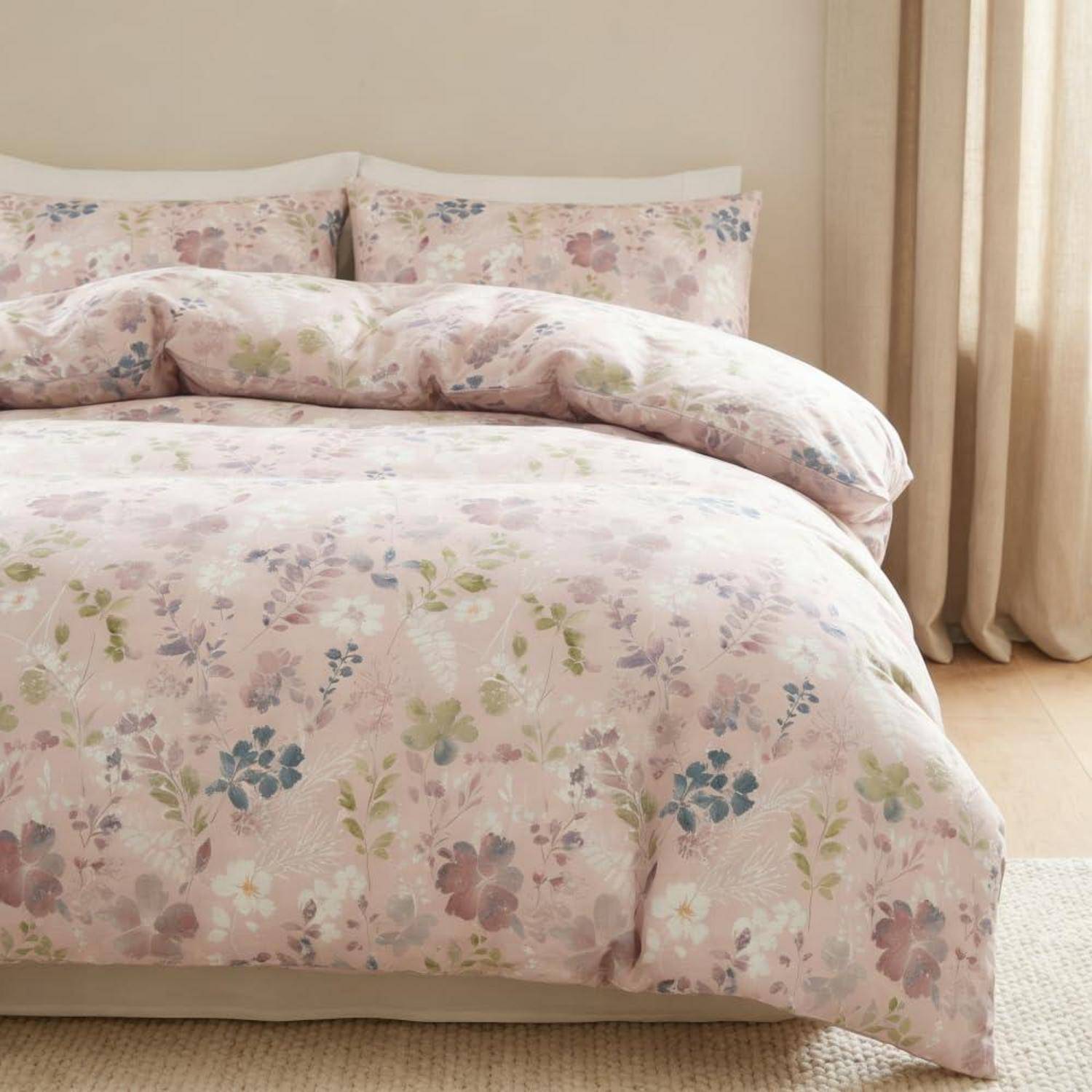 Blumenmustertes Bett mit passenden Kissen und Bettdecke in einem sanft beleuchteten Schlafzimmer.