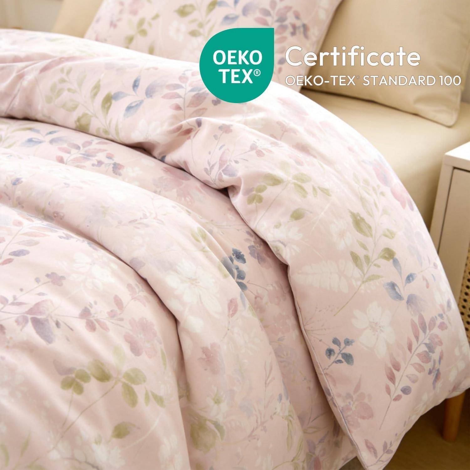 Floraler Pastell-Steppdecke auf einem Bett mit OEKO-TEX Zertifikat, OEKO-TEX Standard 100 Label.