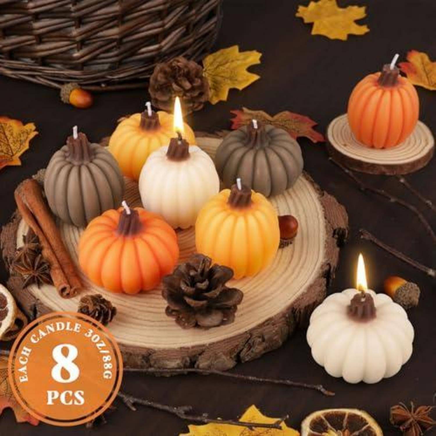 Assortierte kürbisförmige Kerzen, einige angezündet, angeordnet auf Holzscheiben mit Herbstblättern und Tannenzapfen; das Etikett zeigt „8 STK".