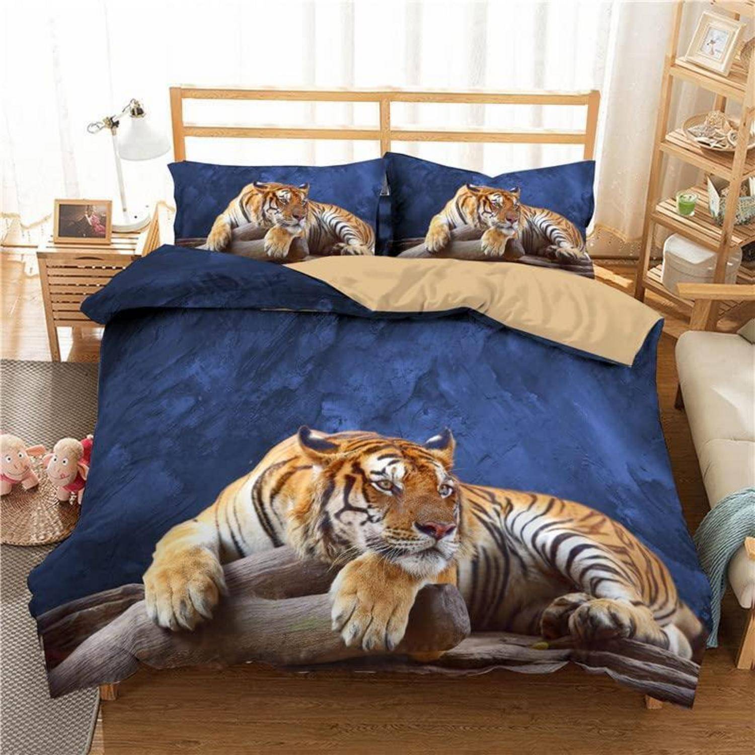Bett mit dunkelblauem Tigermuster-Bettwäsche und Kissen, mit einem großen Tigerbild auf der Bettdecke in einem hellen Schlafzimmer.