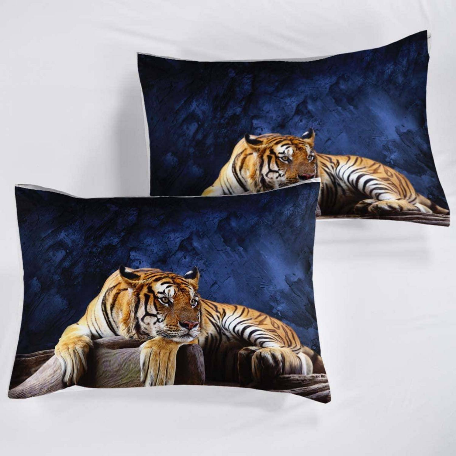 Zwei rechteckige Kissen mit einem ruhenden Tiger-Motiv auf dunkelblauem Hintergrund, übereinander liegend auf einer weißen Oberfläche dargestellt.