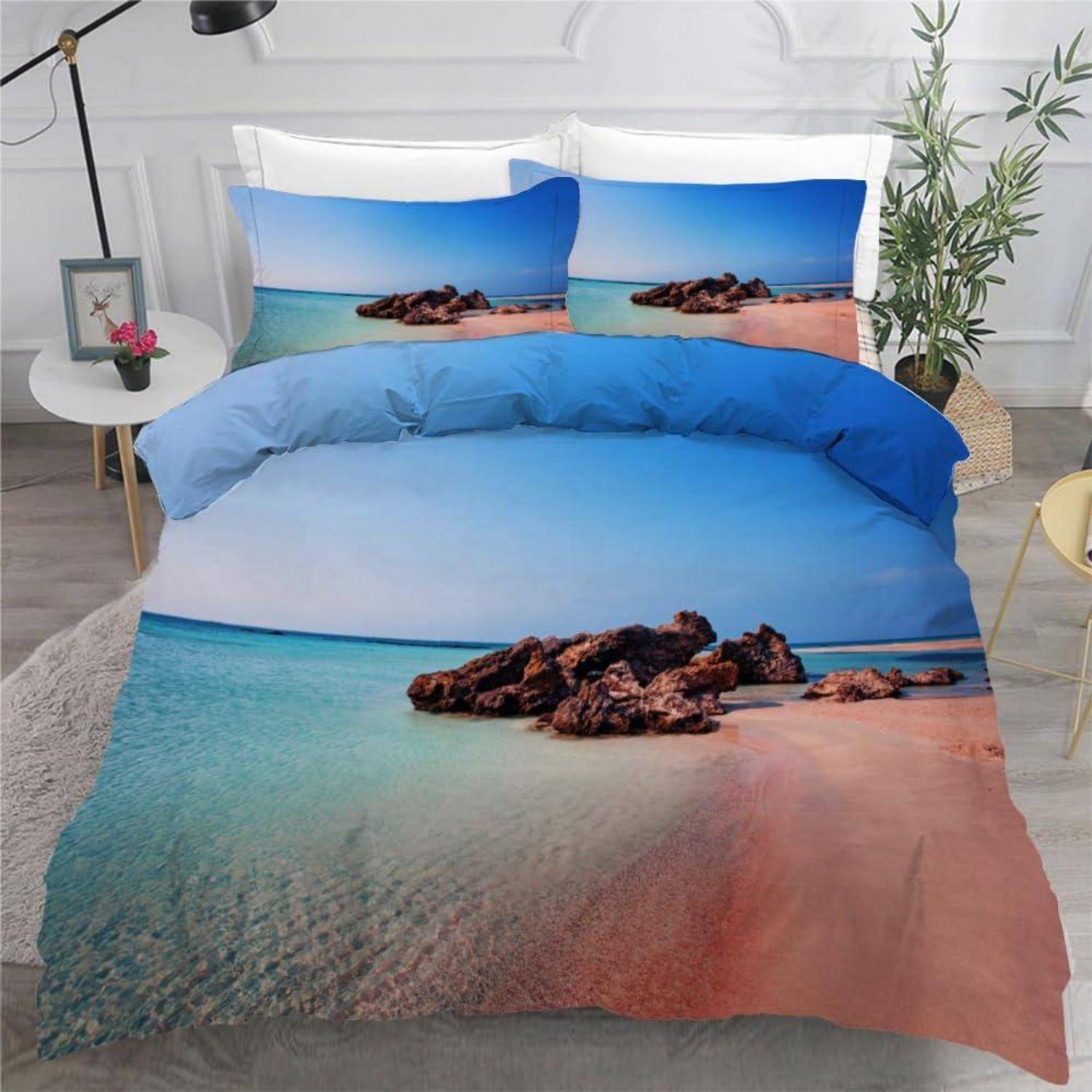 Bett mit Ozean-Strandmotiv-Bettdecke und passenden Kissenbezügen in einer hellen Schlafzimmerumgebung.