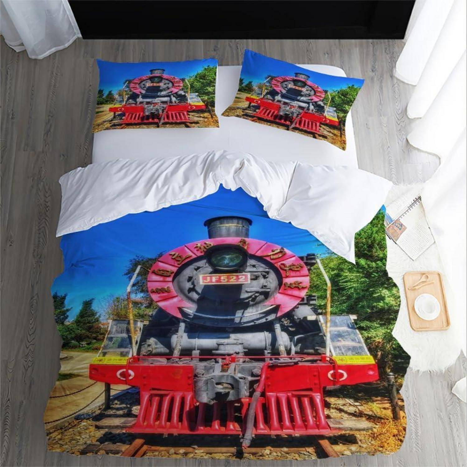 Bett mit passendem Zugdruck-Bettbezug und Kissenbezügen mit einer von vorne gezeigten Dampflokomotive.