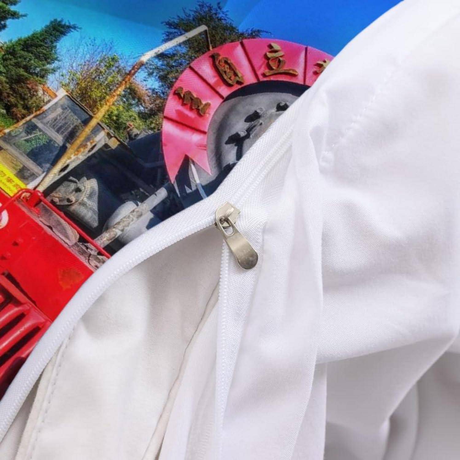 Nahaufnahme eines weißen Kleidungsstücks mit Reißverschluss im Vordergrund, das teilweise ein rotes Außenschild und eine Struktur gegen einen blauen Himmel blockiert.