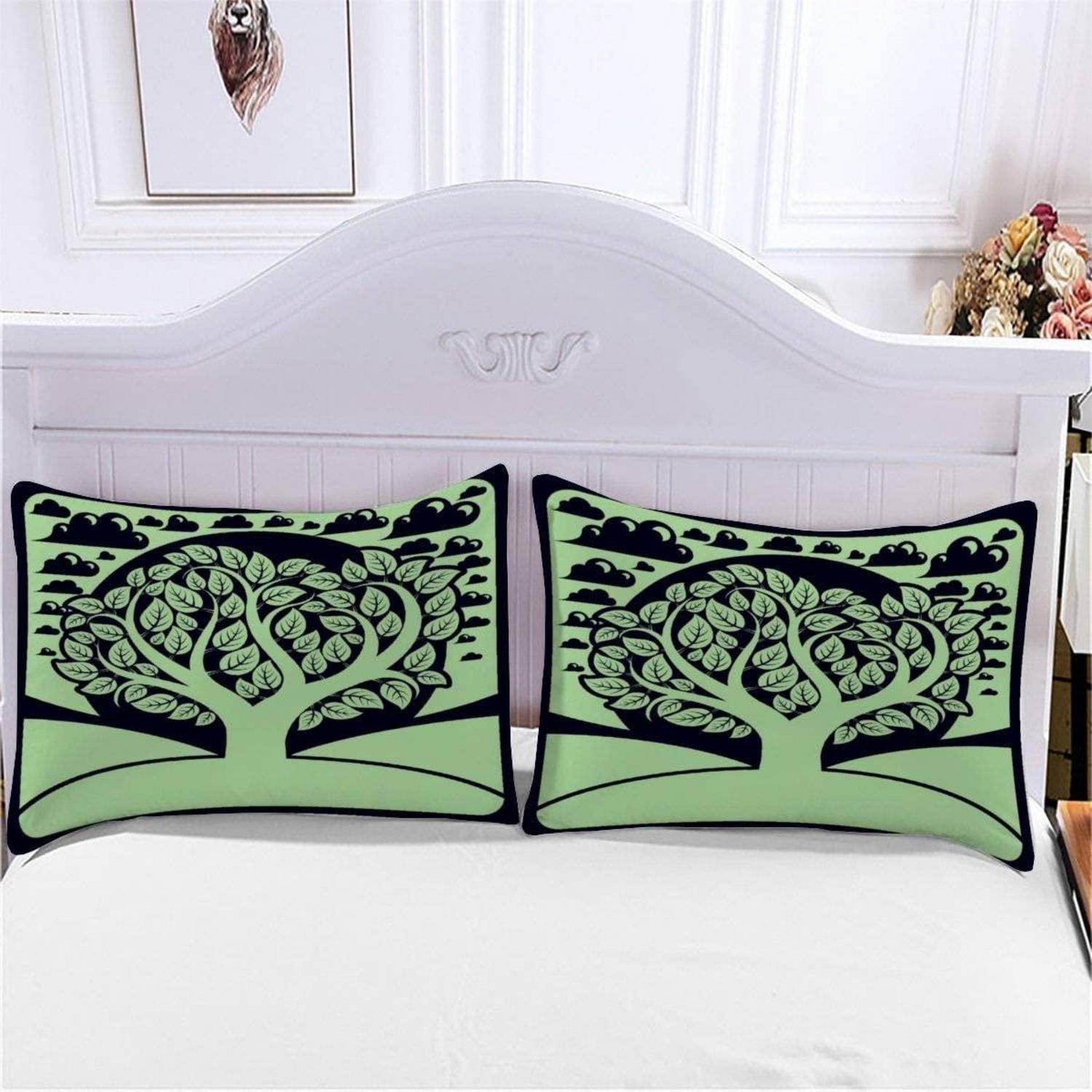 Zwei dekorative grün-schwarze Kissen mit Baummuster liegen auf einem weißen Bett vor einem hellen Kopfteil.