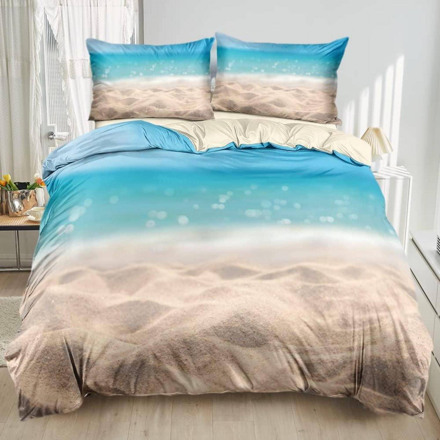 Bett mit ozean- und strandthematischer Bettwäsche, mit Himmelblau- und Sandprint auf der Bettdecke und den Kissen.