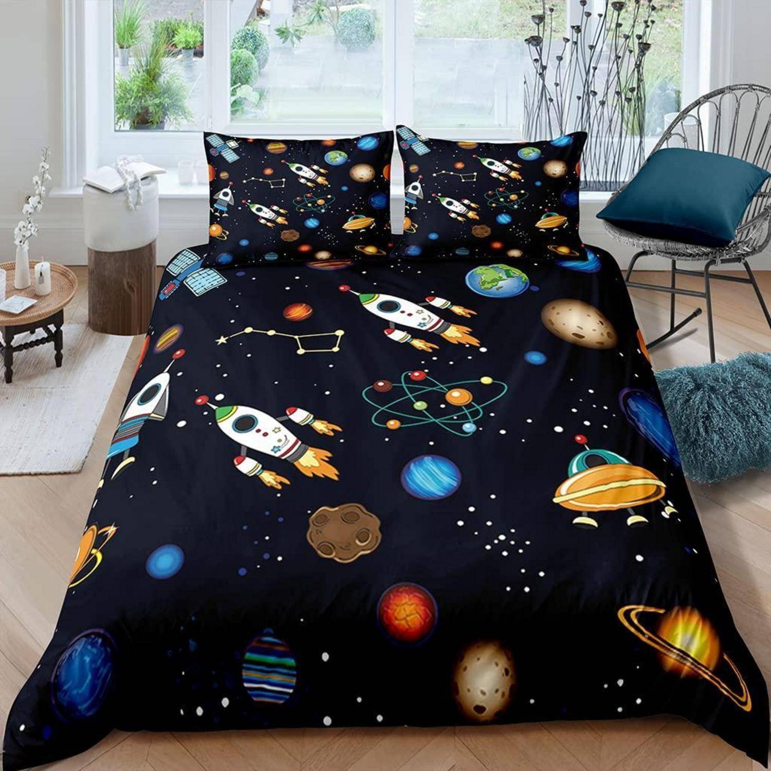 Bett mit schwarzer Weltraum-Bettwäsche mit Raketen, Planeten, Sternen und Sternbildern in einem hellen Schlafzimmer.