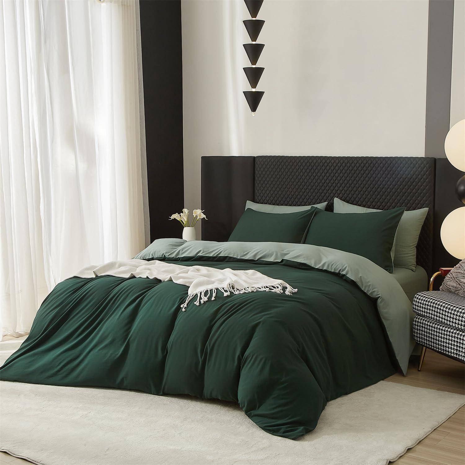 Modernes Schlafzimmer mit einem Bett mit dunkelgrüner Bettwäsche und Kissen, schwarzem Kopfteil, hellen Vorhängen und minimalistischer Wanddekoration.