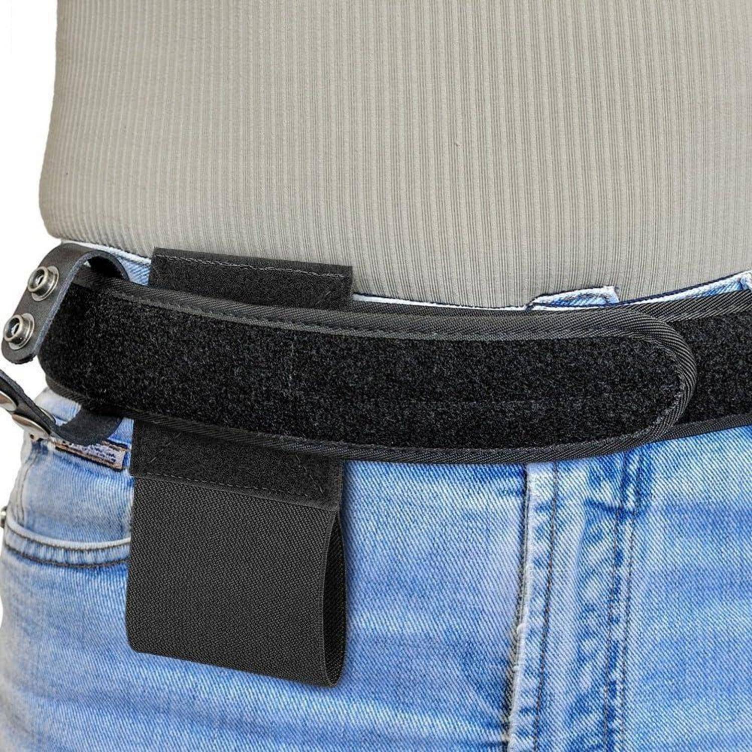 Schwarzer Hüftgürtel-Holster, der über die Jeans geklemmt ist, mit einer baumelnden Tasche auf der Körpermitte einer Person.