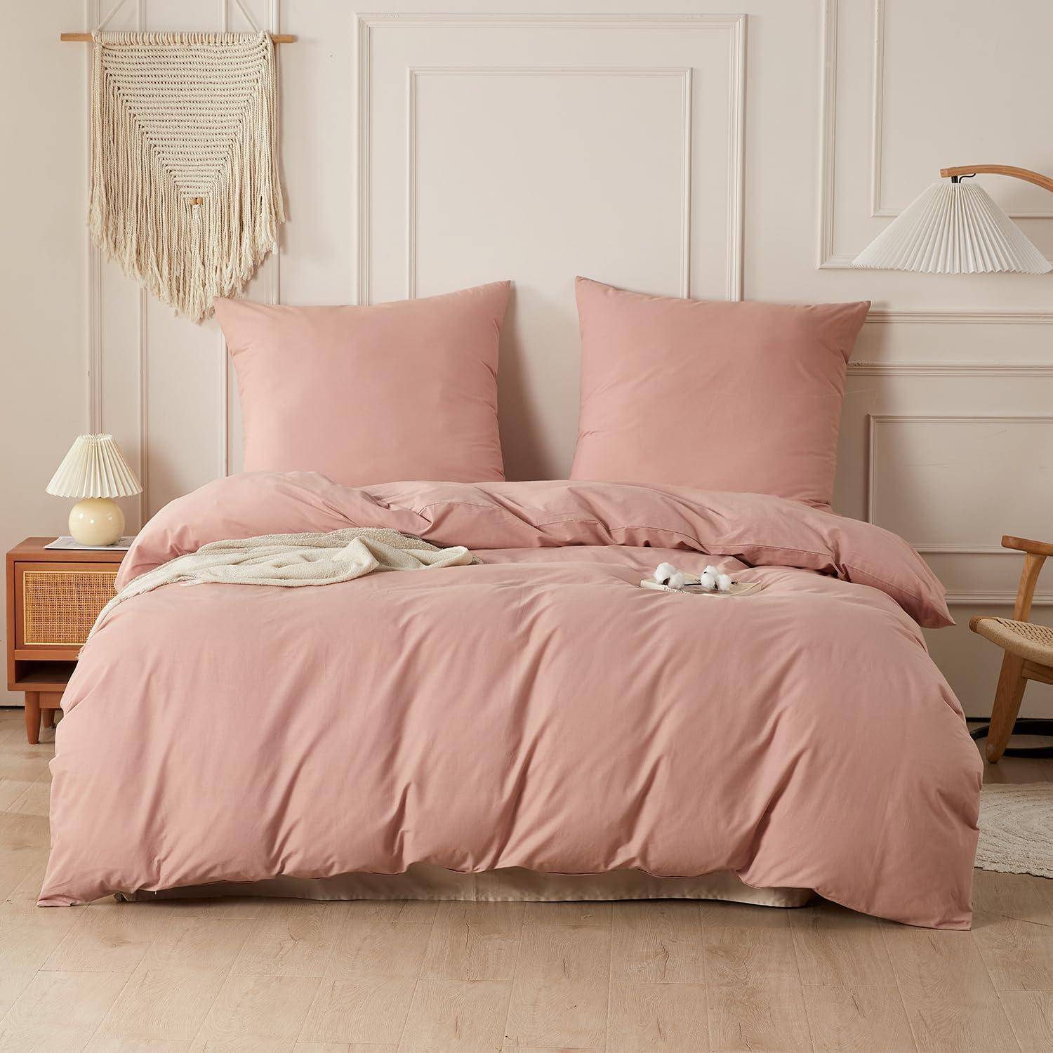 Rosa Bett mit passenden Kissen und Bettdecke in einer weichen, minimalistischen Schlafzimmereinrichtung.