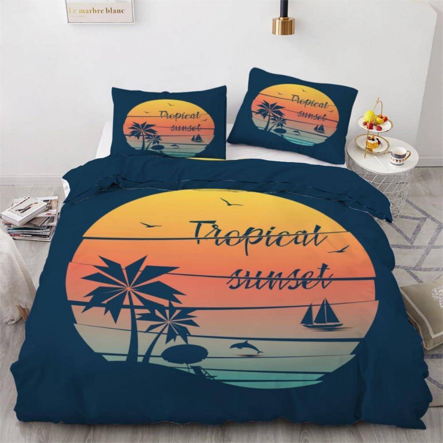 Bett mit dunkelblauem tropischem Sonnenuntergang-Bettwäsche-Set, das ein großes Sonnenuntergang-Motiv, Palmen, Vögel und die Worte „Tropical sunset