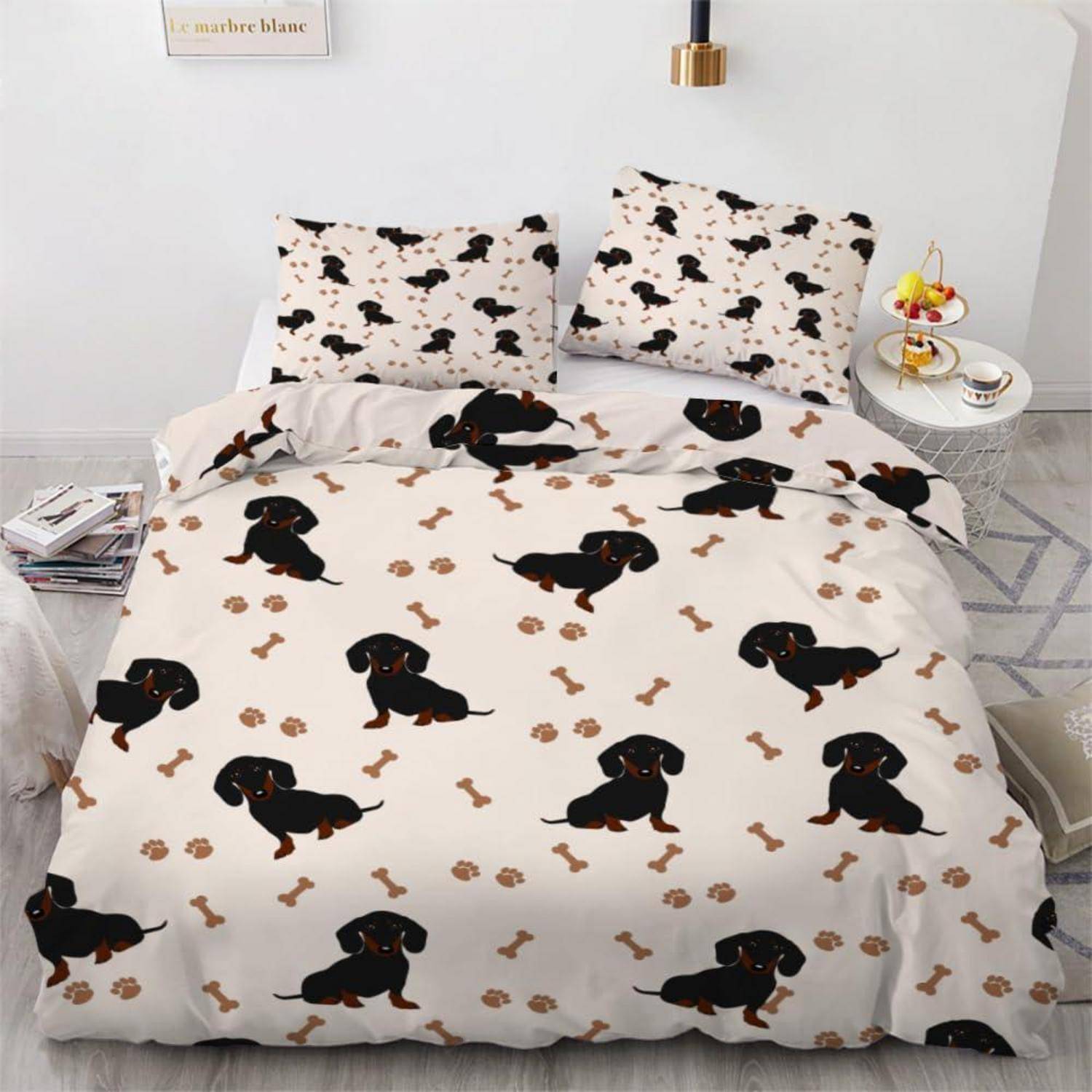 Schlafzimmerbett mit Dackelmustern-Bettwäsche und passenden Kissen in einem hellen, minimalistischen Raum mit einem kleinen Nachttisch.