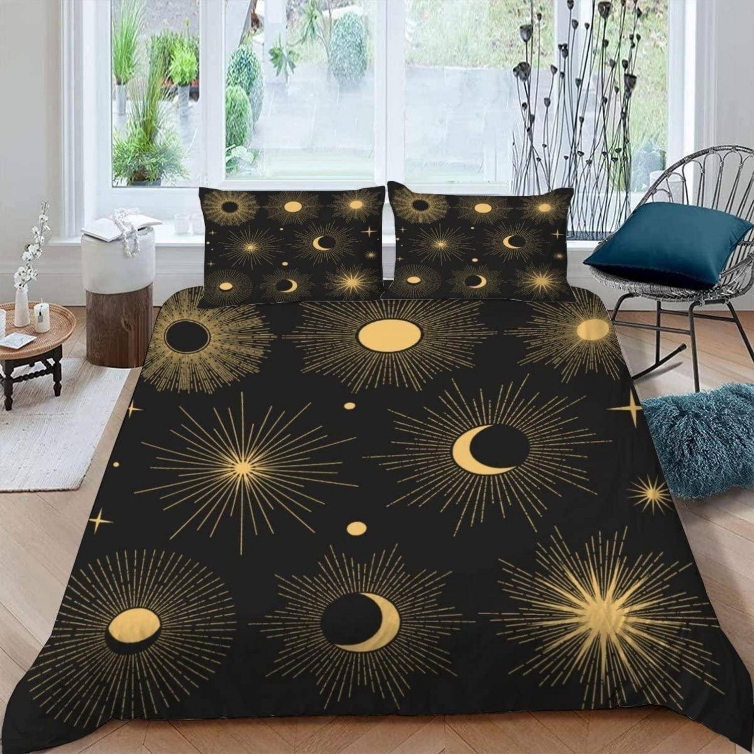 Schwarzer Bettwäschesatz mit goldenem Sonne- und Mondburst-Muster, gezeigt auf einem Bett in einem hellen modernen Schlafzimmer.