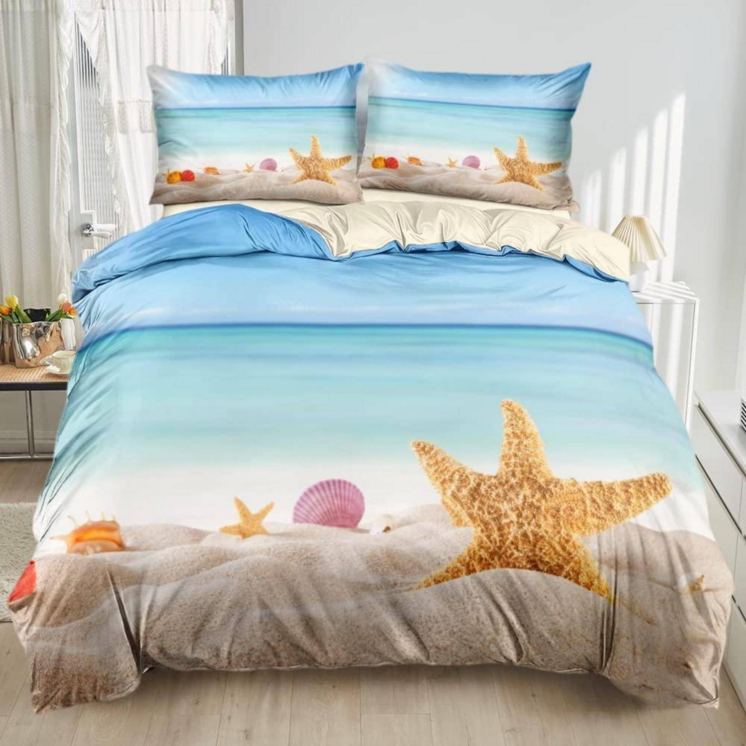 Ein Bett, das mit strandhematischer Bettwäsche eingedeckt ist, mit Ozean-, Sand-, Muschel- und Seesternmotiven auf dem Bettdecken- und Kissenbezug.