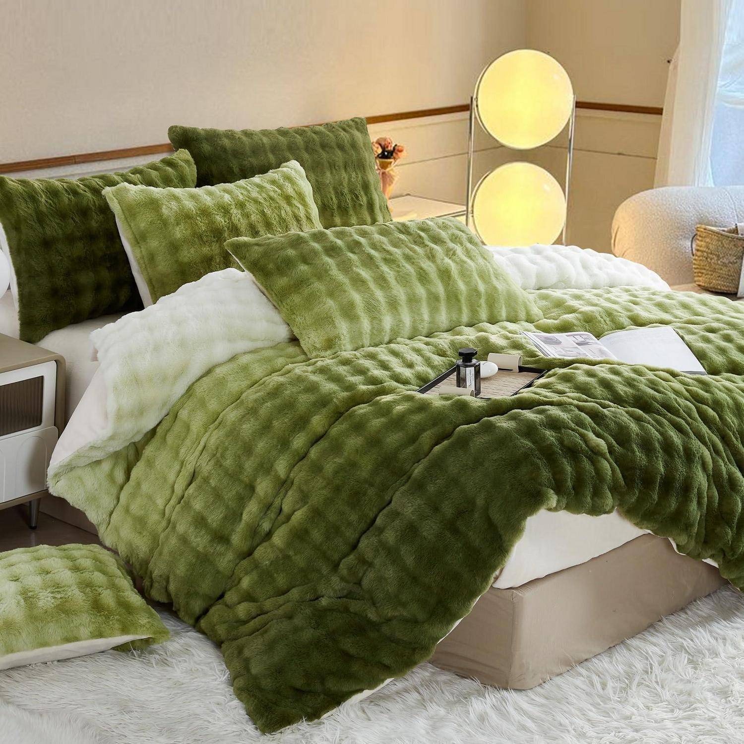 Grüne strukturierte Bettwäsche mit gestapelten Kissen und einer weißen Wurfdecke auf einem beigen Bett in einem sanft beleuchteten Schlafzimmer.