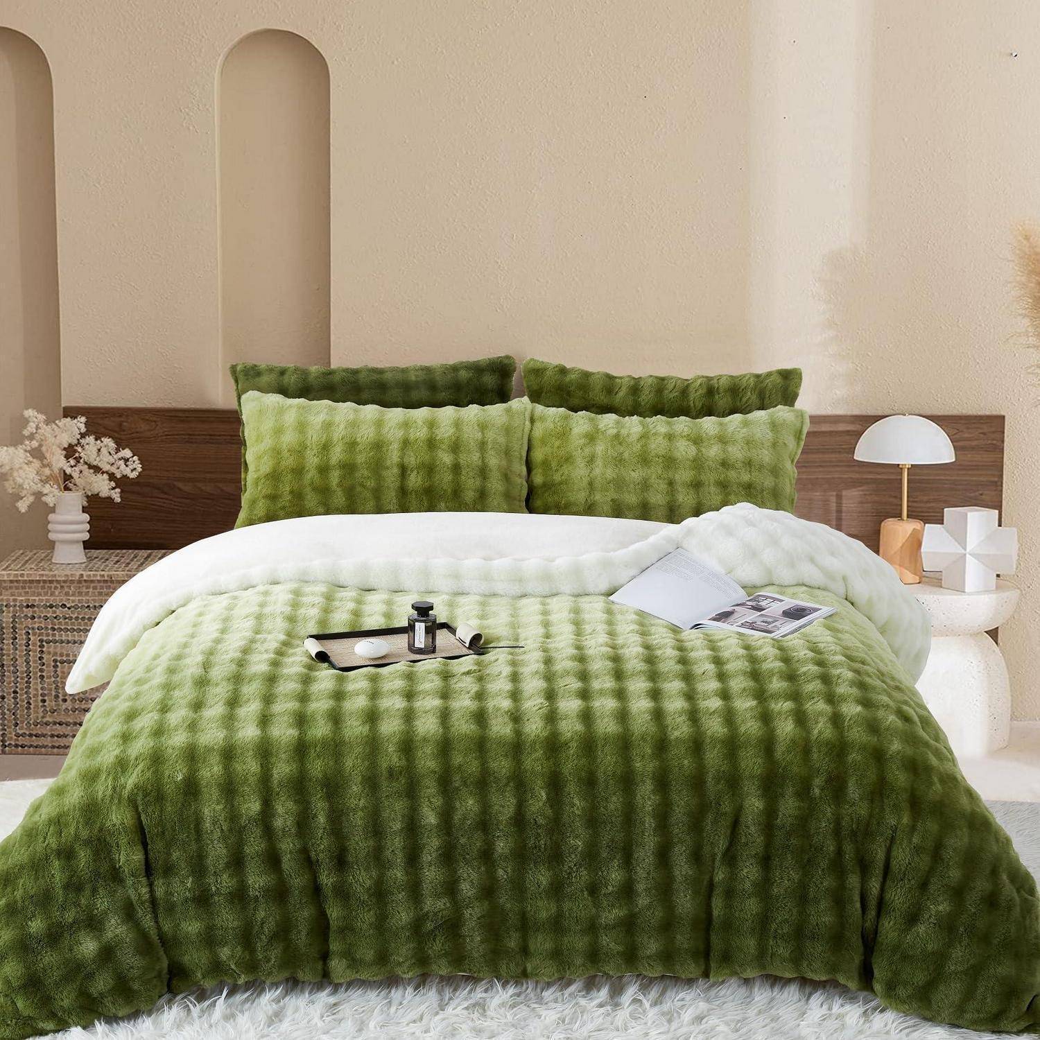 Bett mit grüner strukturierter Bettwäsche, weißer Decke und Kissen in einem minimalistischen Schlafzimmer mit Nachttischen und Lampen.