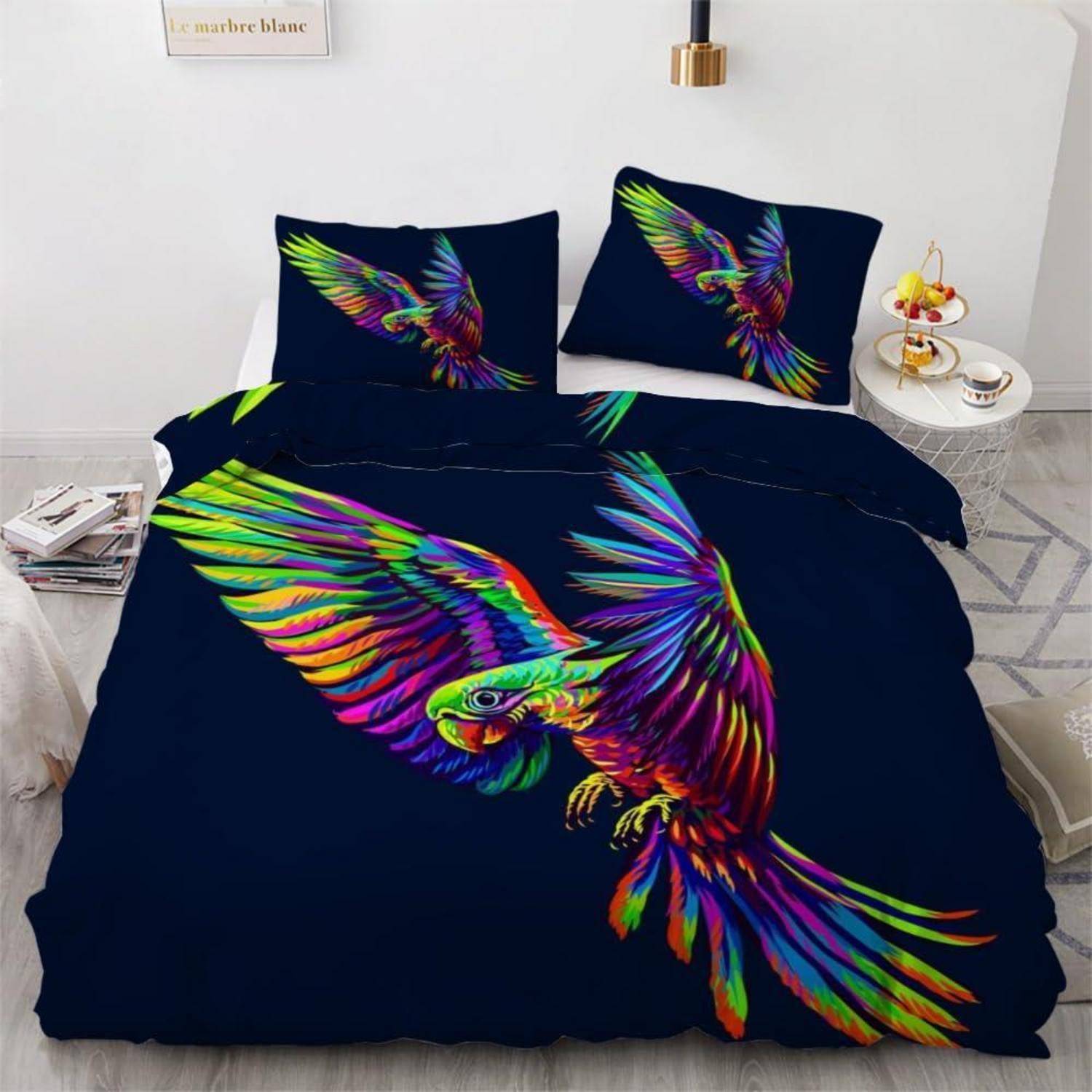 Buntes Papageienbettwäsche-Set auf dunkelnavyblauem Hintergrund, mit einem großen fliegenden Vogel auf der Bettdecke und passenden Vogel-Kissen in einem modernen Schlafzimmer.